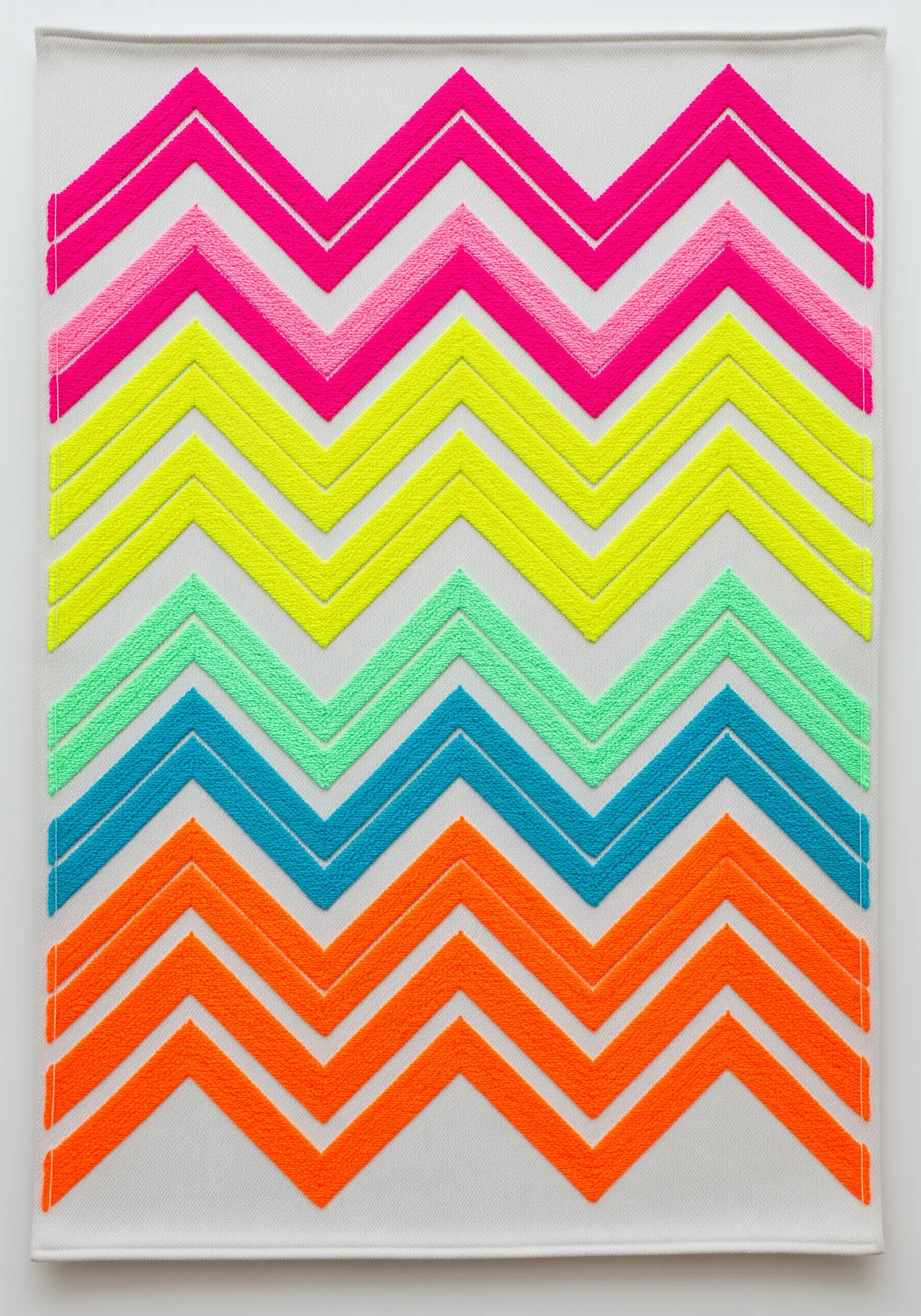 A colorful neon chevron pattern embroidered with thick satin stitches in rainbow colors.