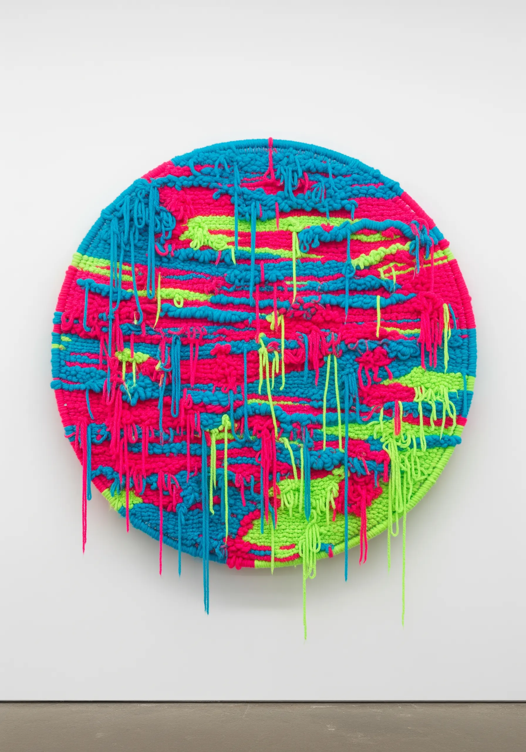 Circular neon weaving with dripping yarn tails in cyan and magenta