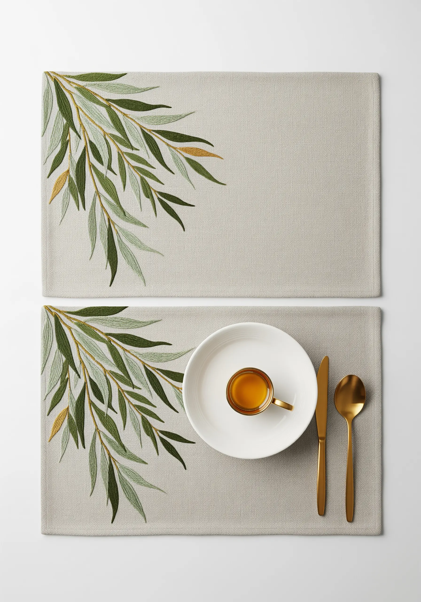 Embroidered olive branches with green and gold leaves on a set of placemats.