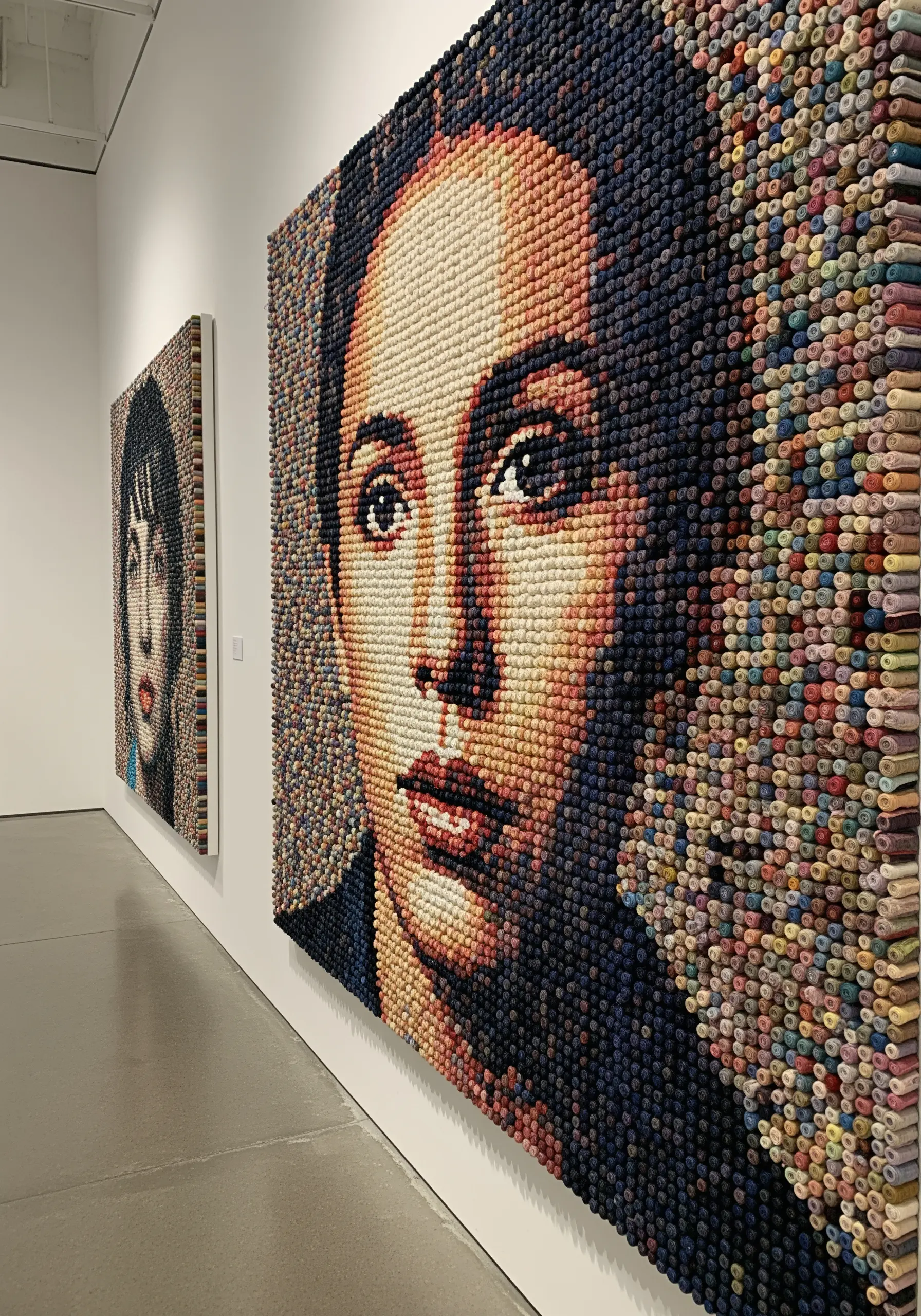 A large, photorealistic portrait made from thousands of spools of thread arranged like pixels.