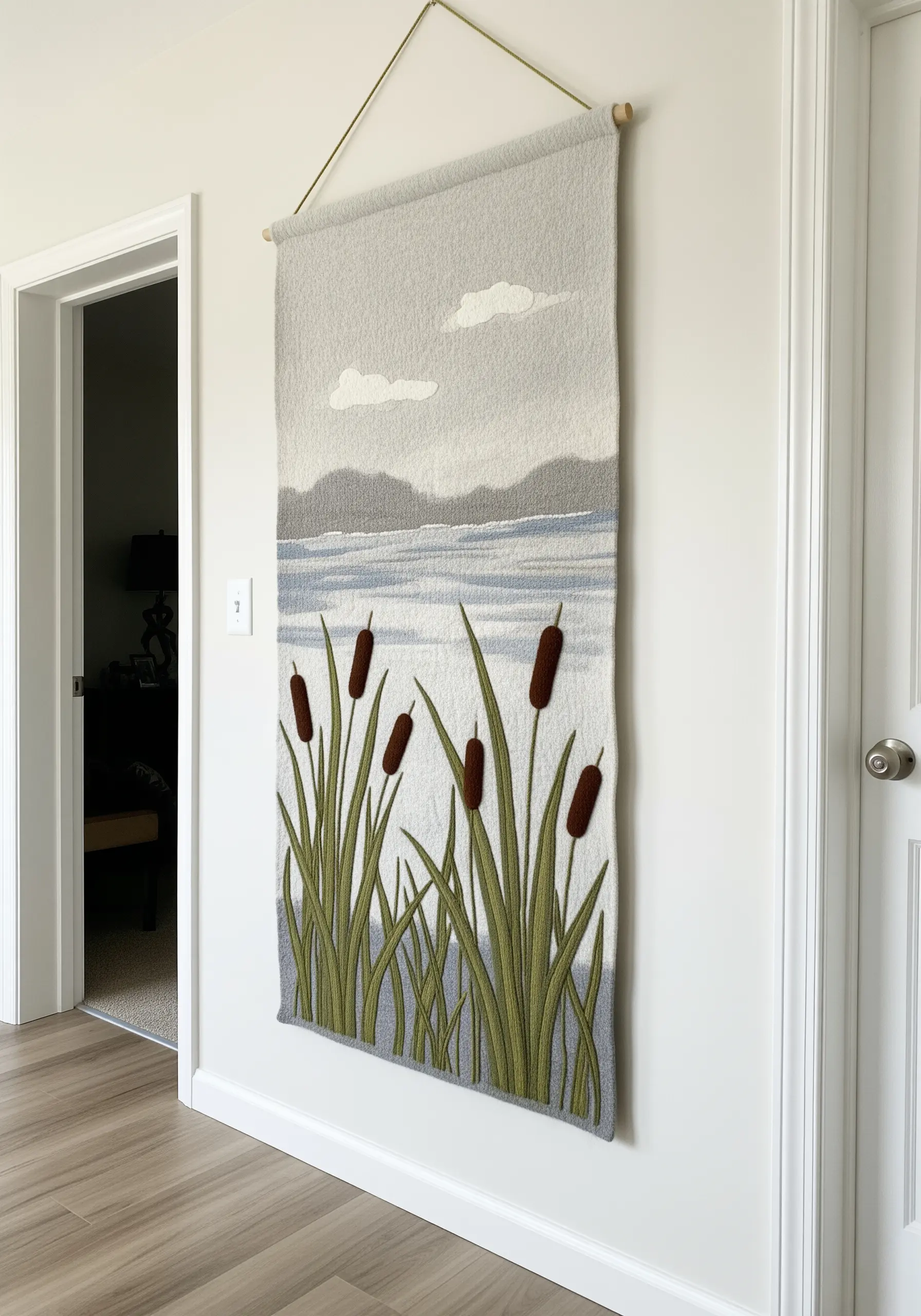 A wall hanging depicting a calm lakeside scene with cattails, created with soft, blended stitches.