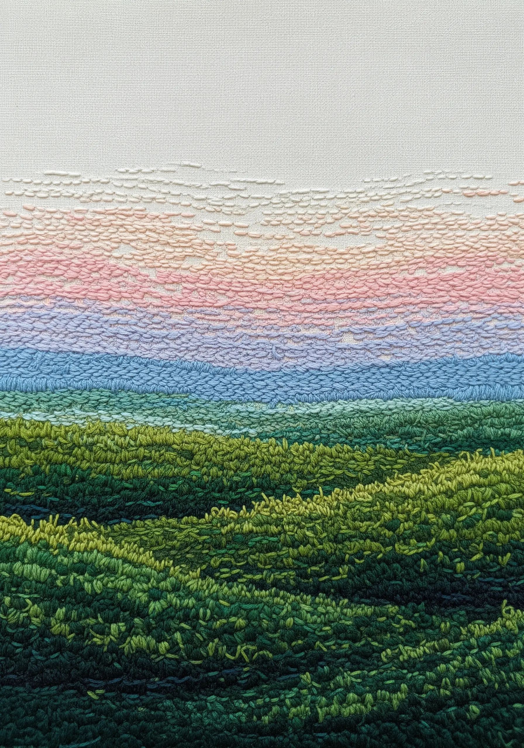 An abstract landscape of rolling hills created with dense seed stitches in a pastel gradient.