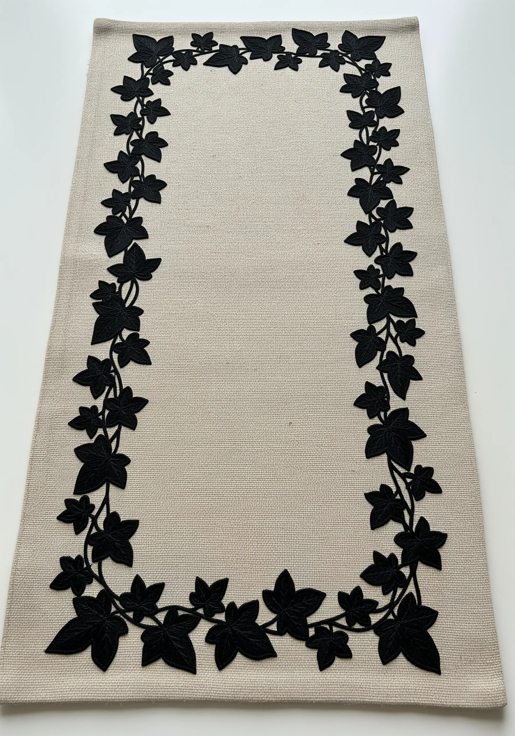 A bold, solid black ivy silhouette border on a natural, textured linen table runner.