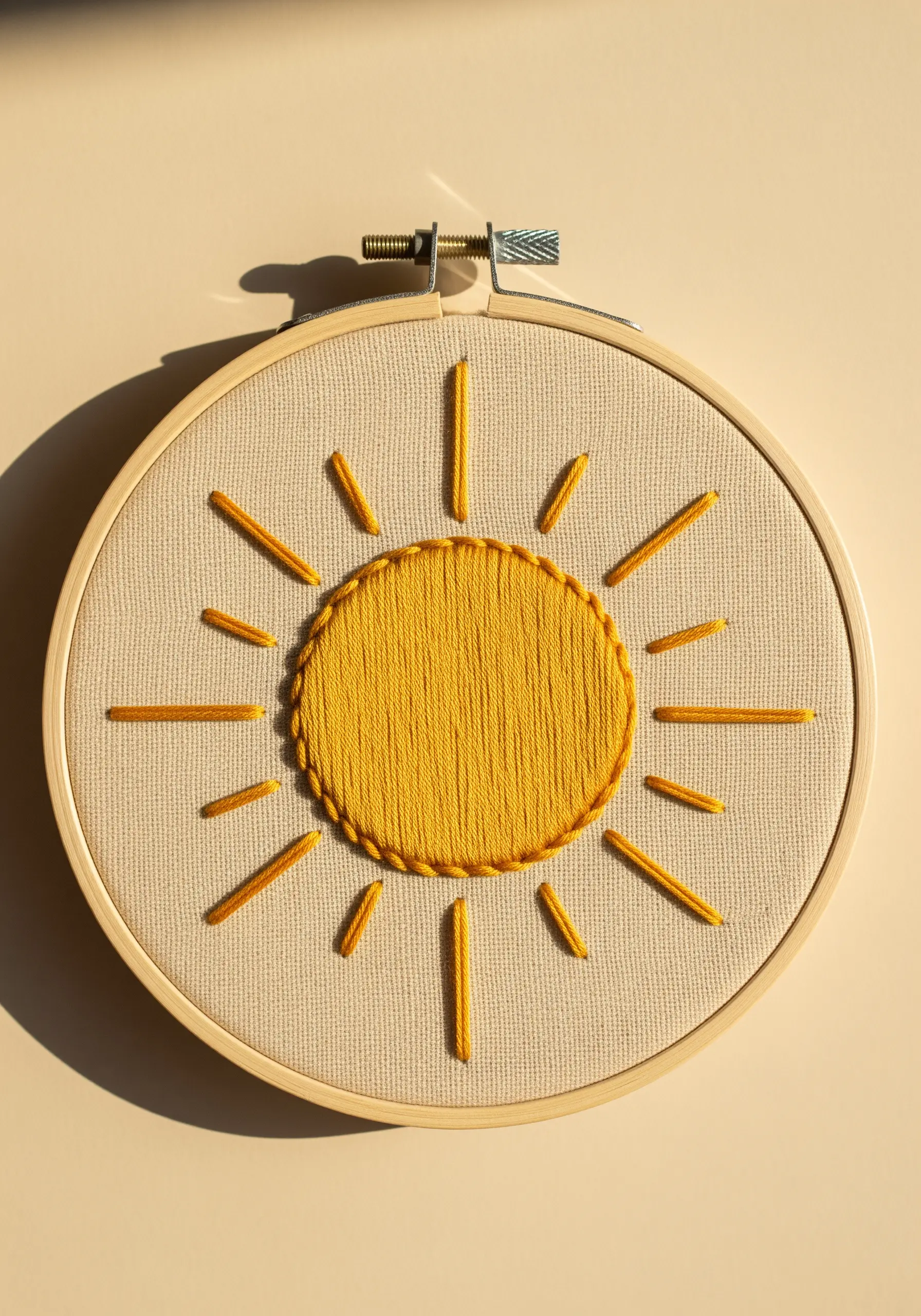 A bright yellow sun embroidered with satin stitch and straight stitch rays.