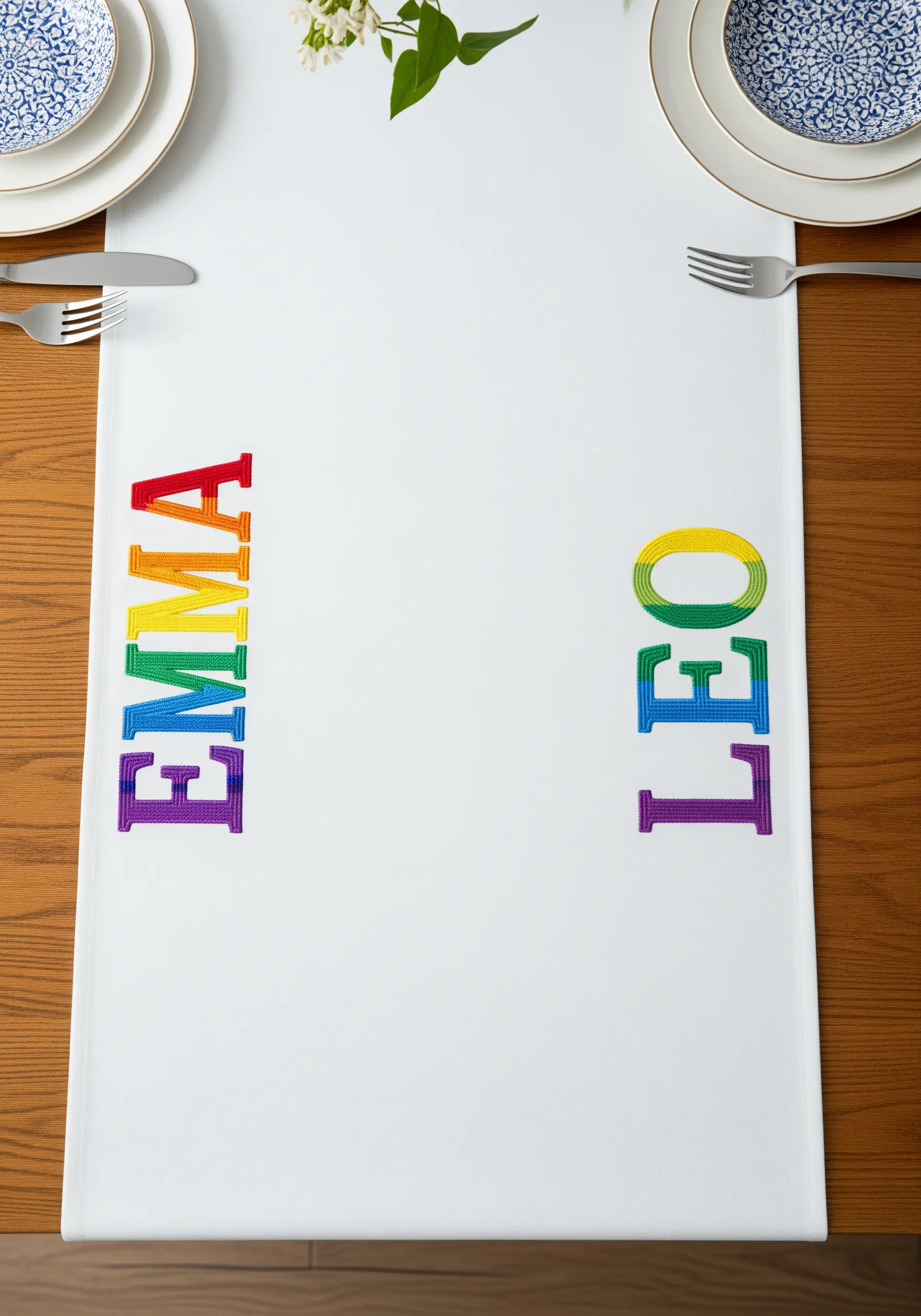 A table runner with names embroidered in rainbow gradient block letters.