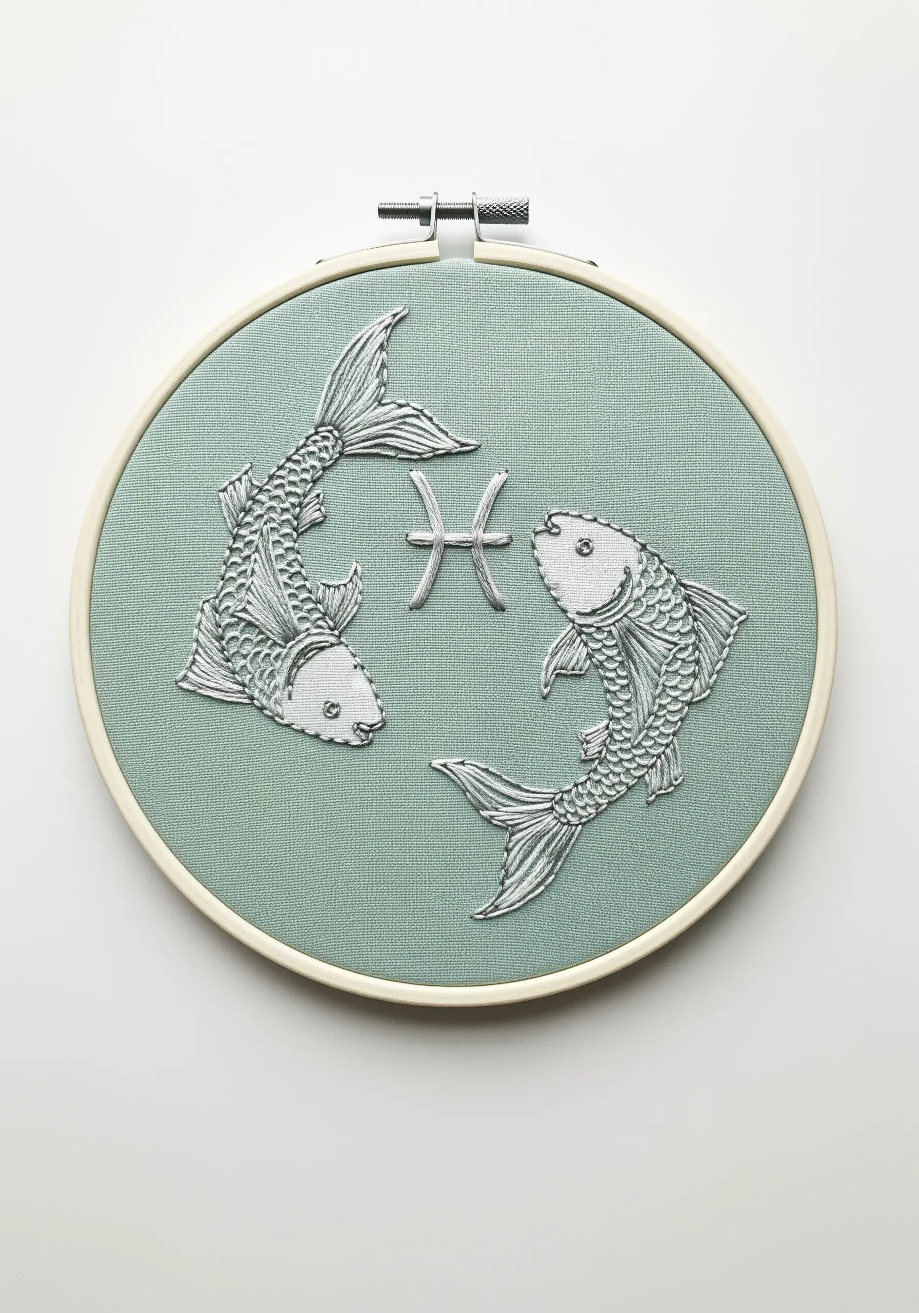 Two realistic Pisces fish thread-painted in silvery grey thread on a light green fabric.