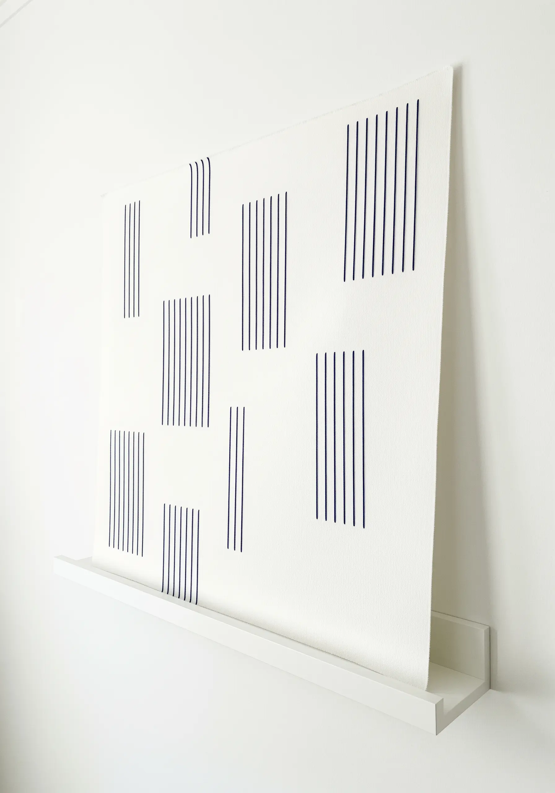 Minimalist art with blocks of evenly spaced vertical black lines on white canvas.
