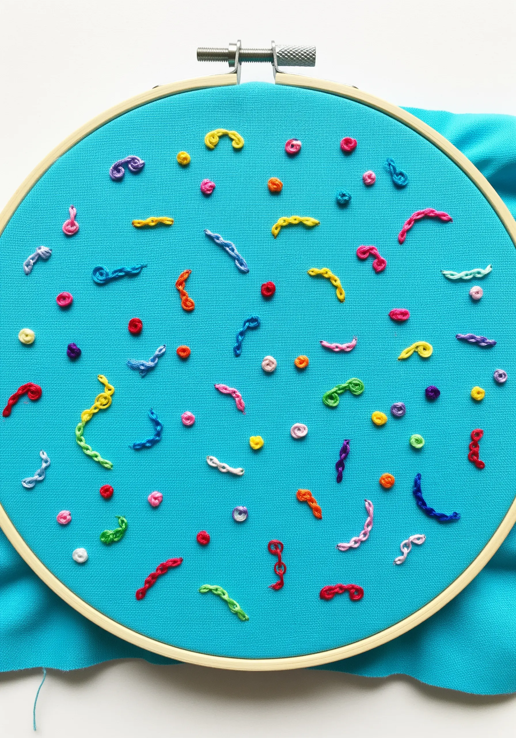 Scattered abstract shapes in bright colors on a turquoise background.