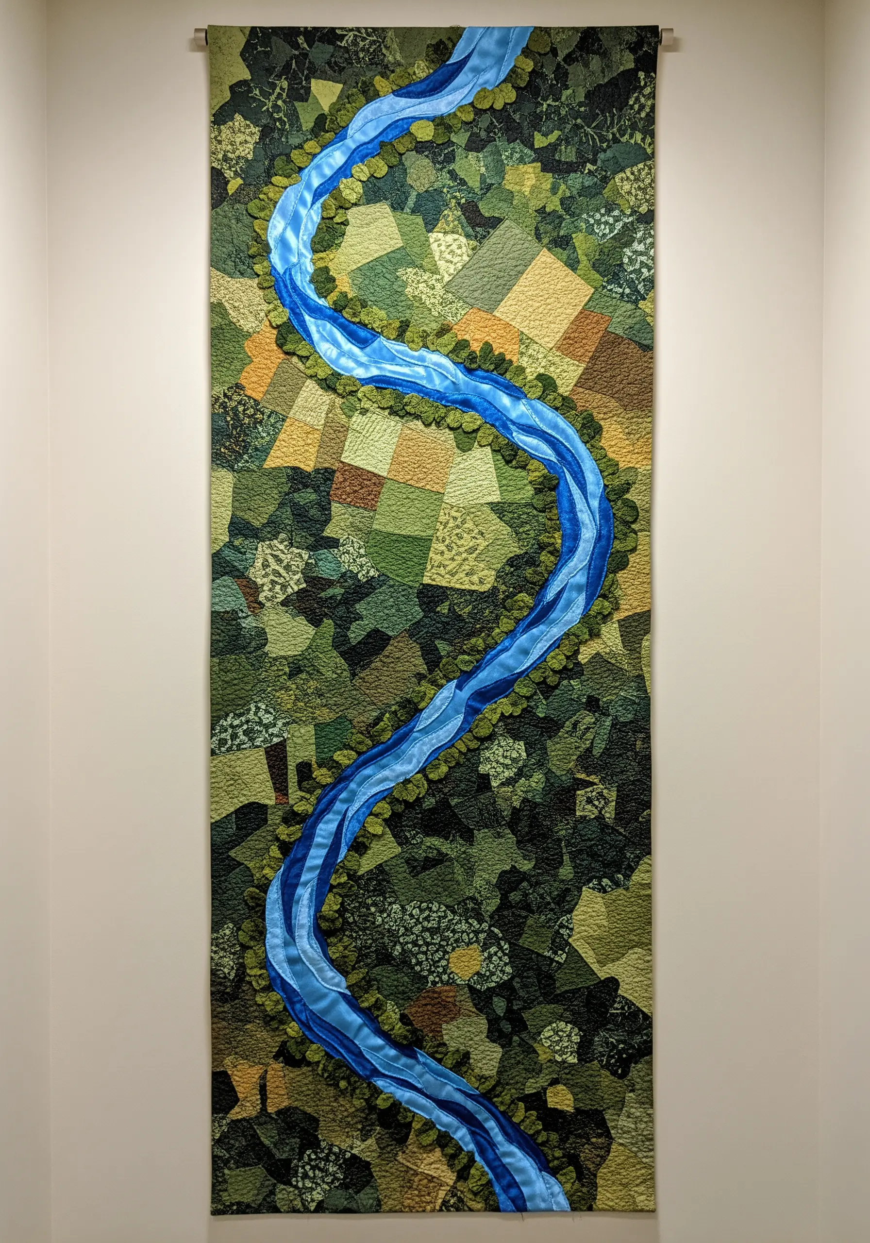 A long wall tapestry depicting an aerial view of a river flowing through patchwork green fields.