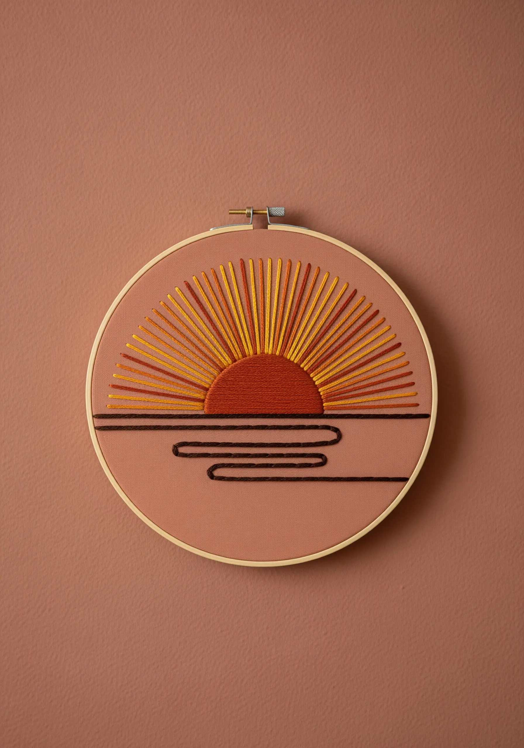 A stylized sunburst embroidered with radiating straight stitches in red, orange, and yellow.