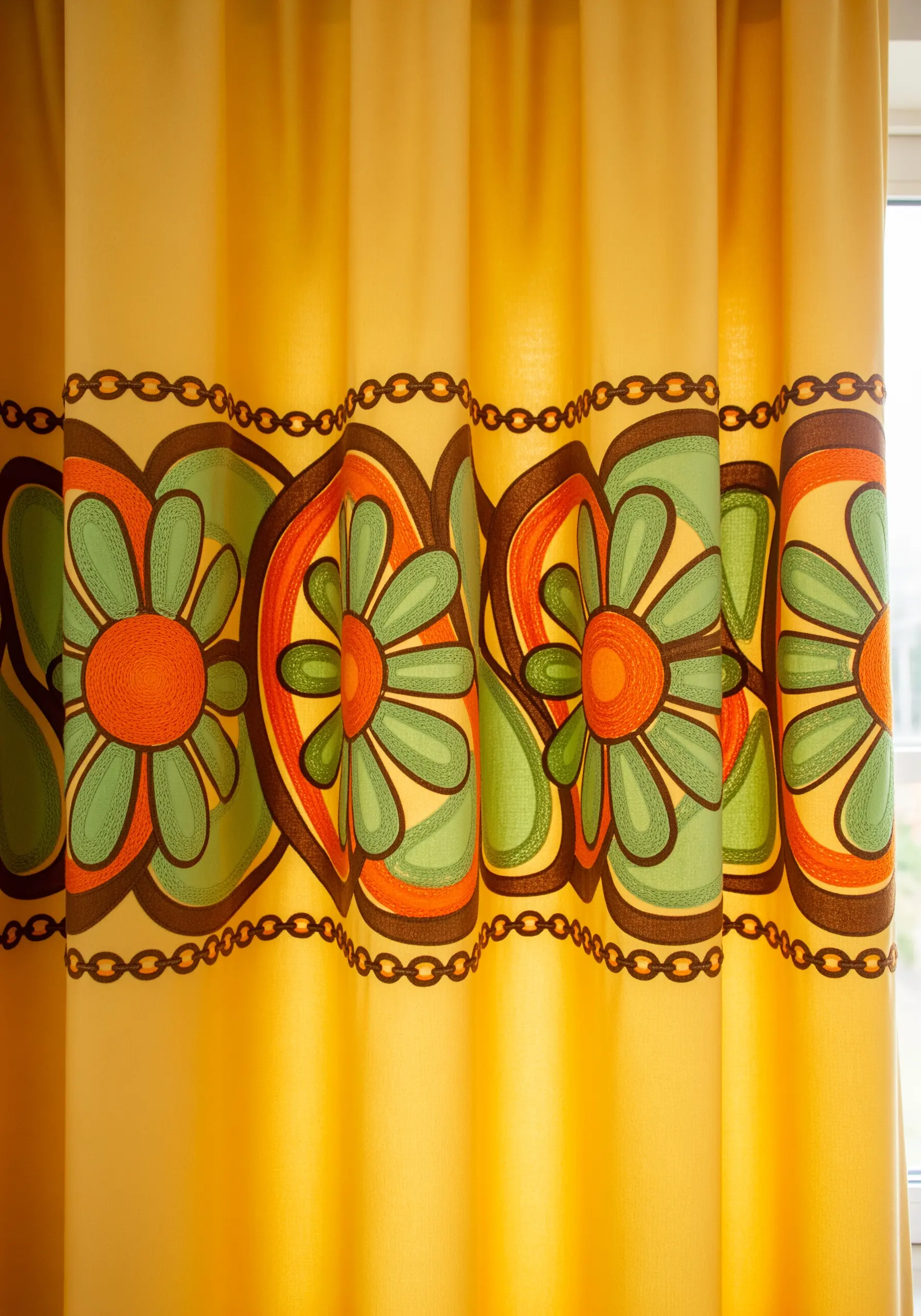 A retro 1970s floral pattern in orange, green, and brown on yellow curtains.