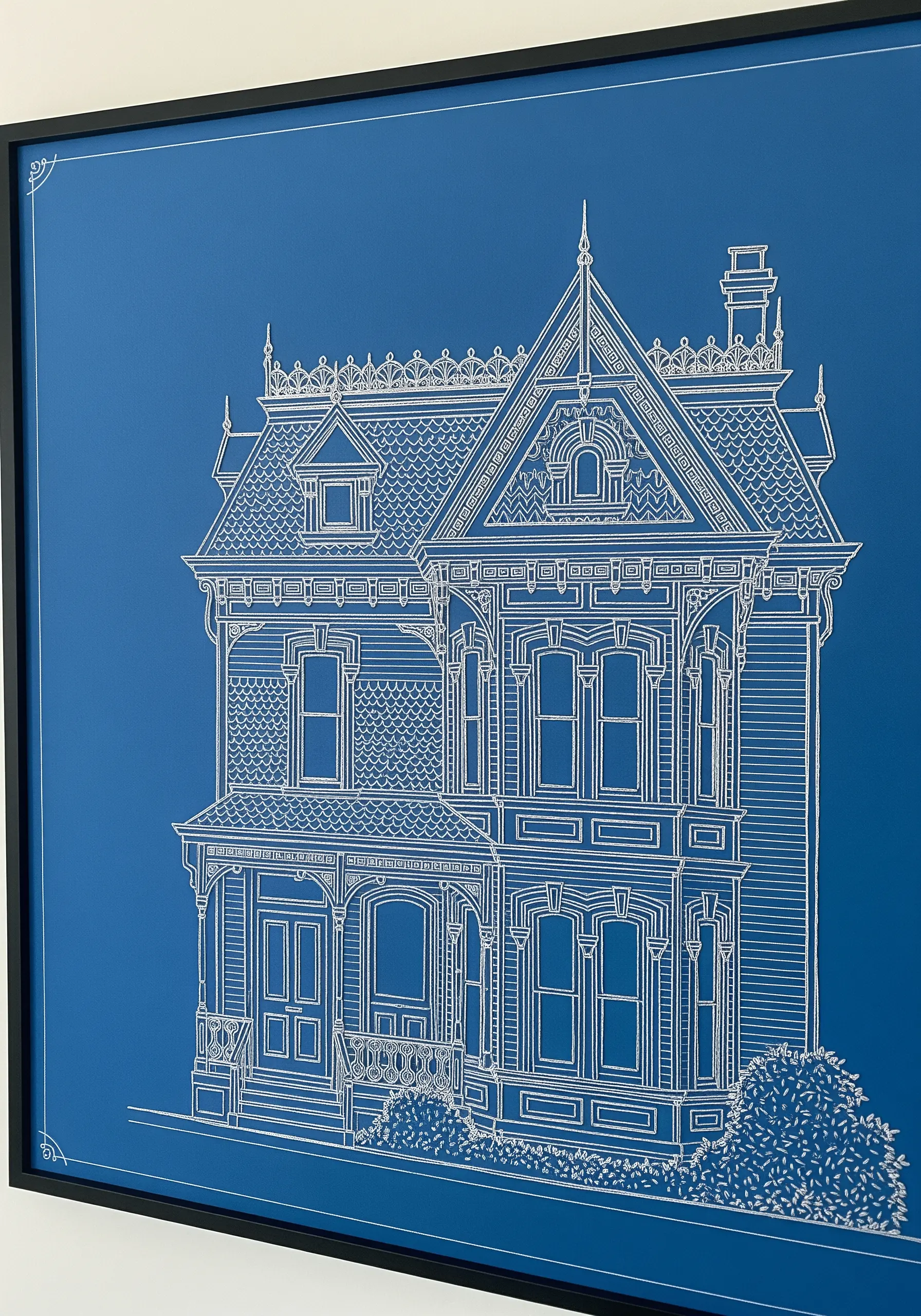 An architectural blueprint of a Victorian house stitched with white thread on blue paper.