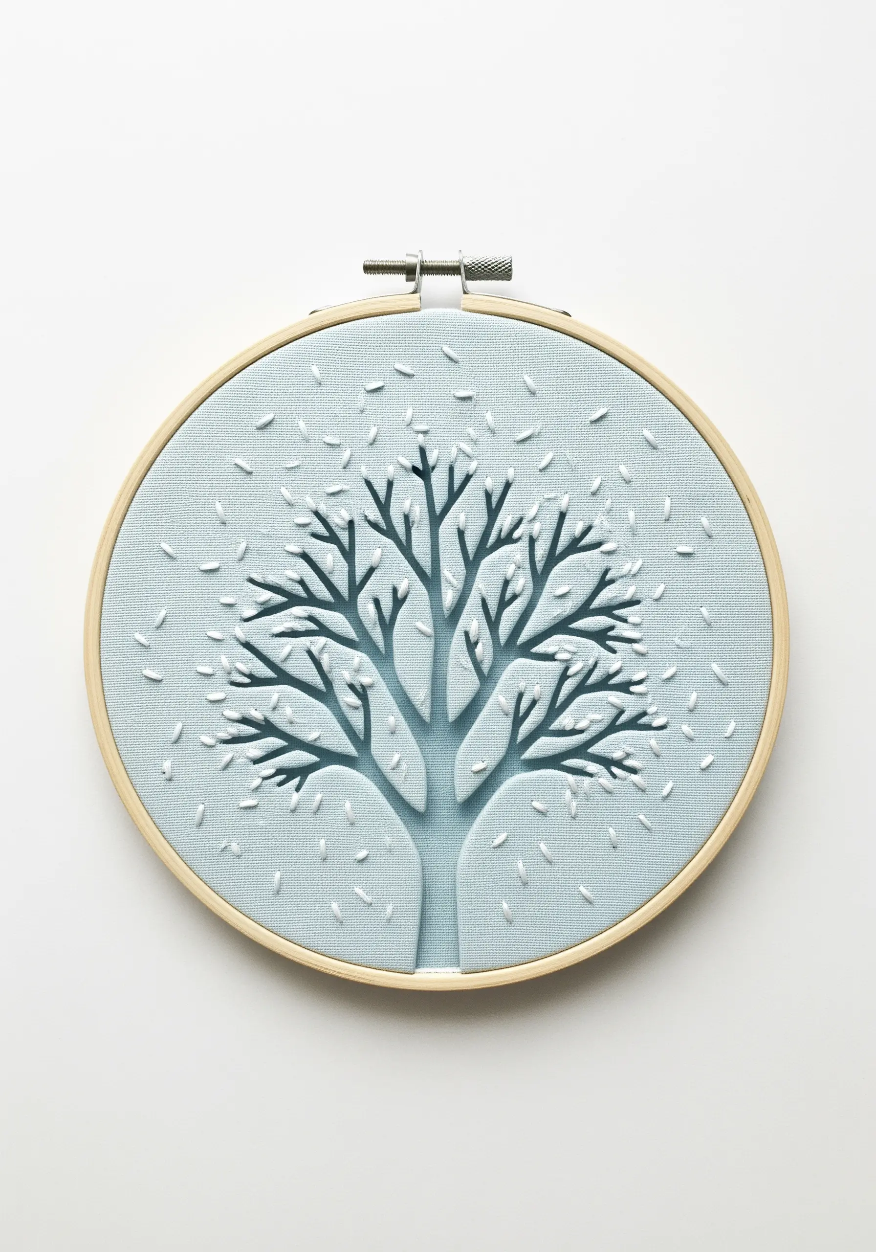 A tree silhouette created from cut-out fabric, with the background featuring tiny white seed stitches.