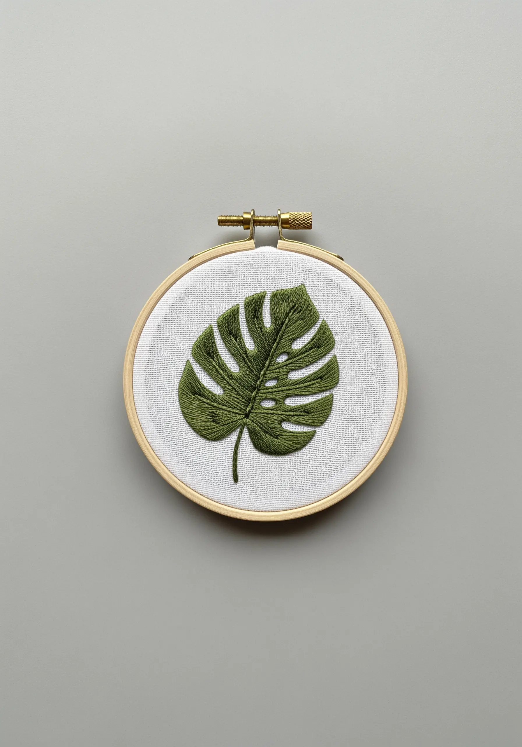 A detailed Monstera leaf filled with green long-and-short stitch for a textured effect.