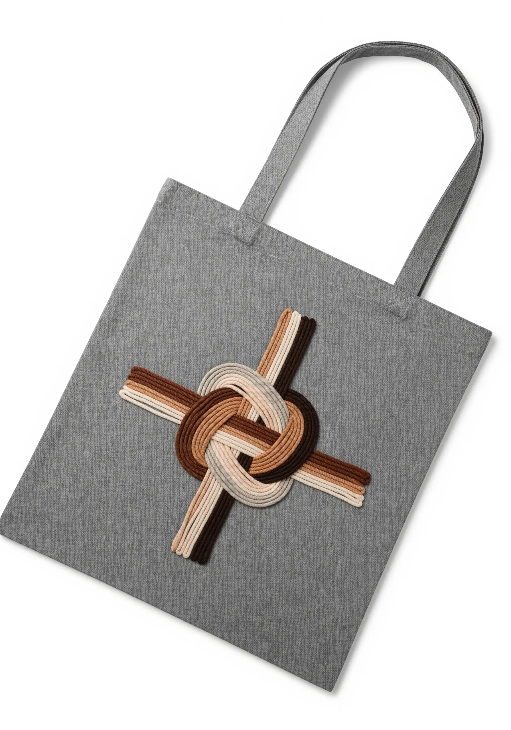 A 3D unity knot made with couched cords in neutral tones on a gray tote bag.
