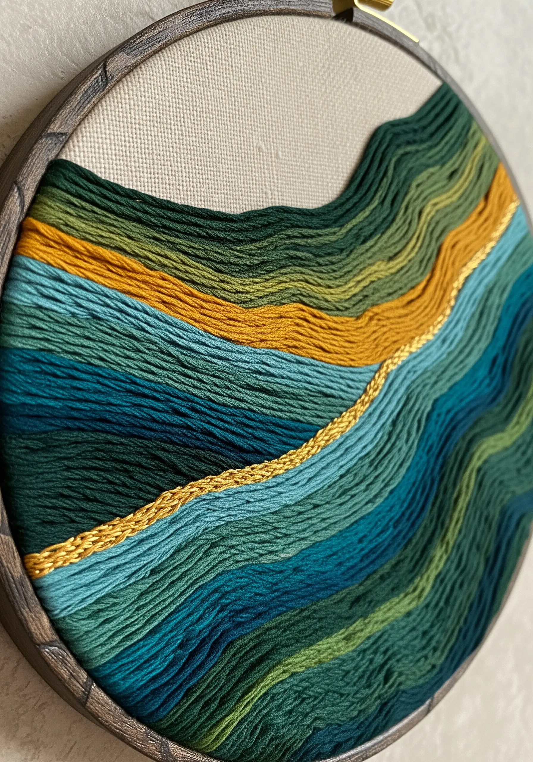 Abstract embroidered landscape with green, blue, and gold contoured satin stitches.
