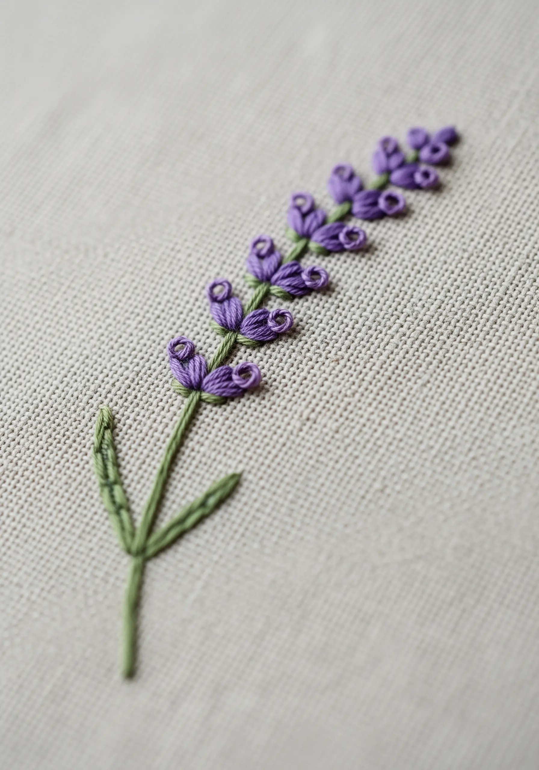 Close-up of a lavender sprig embroidered with purple bullion knots.