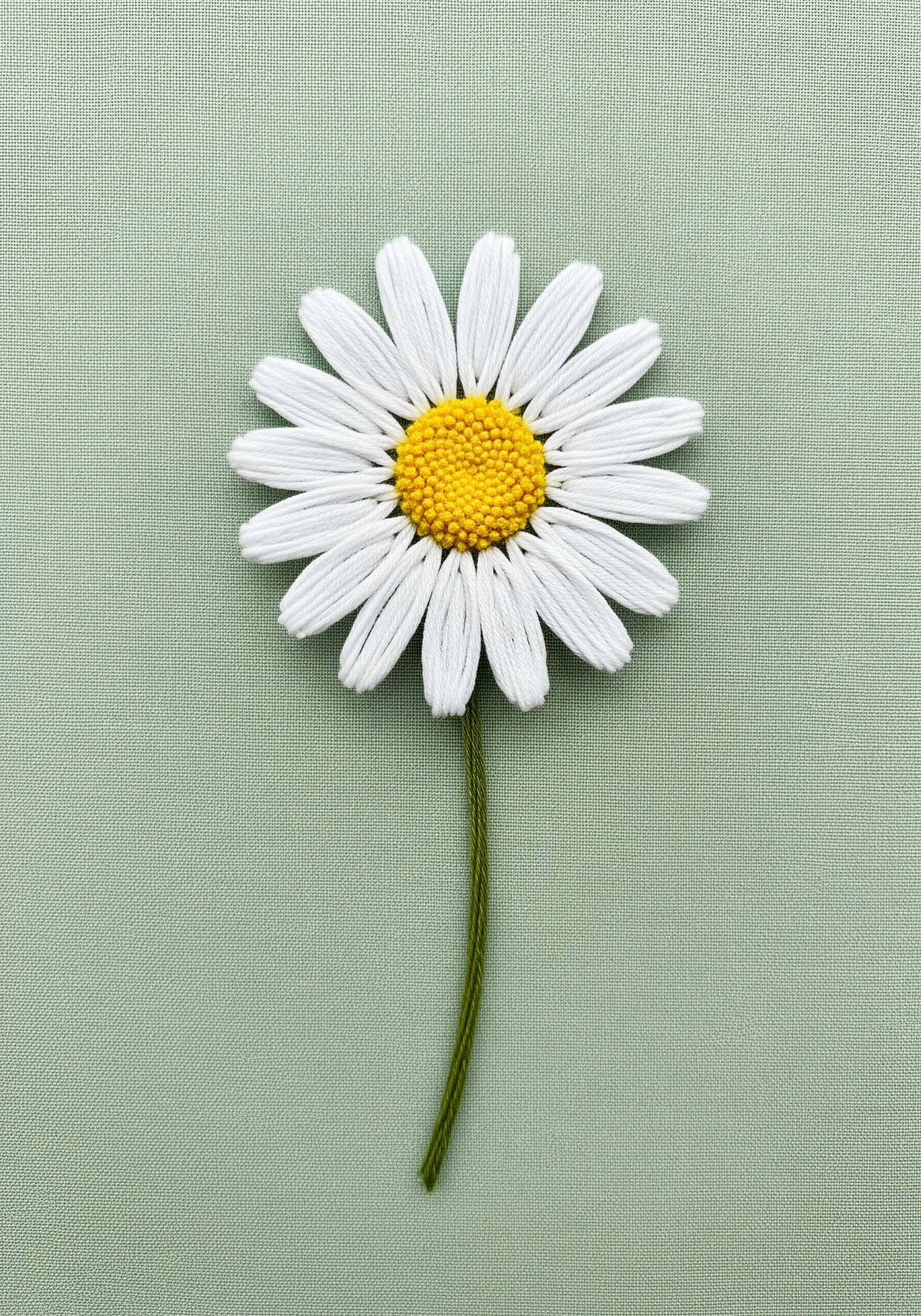 Single white daisy embroidery with yellow french knot center