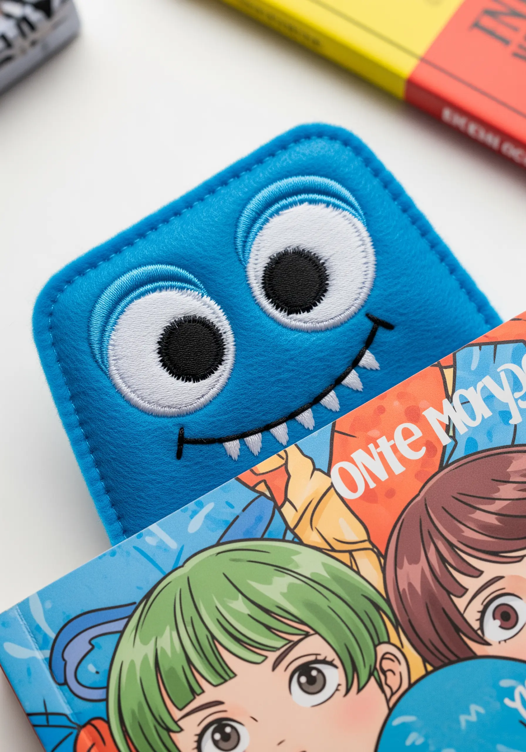 A bright blue felt corner bookmark designed to look like a cute, googly-eyed monster.