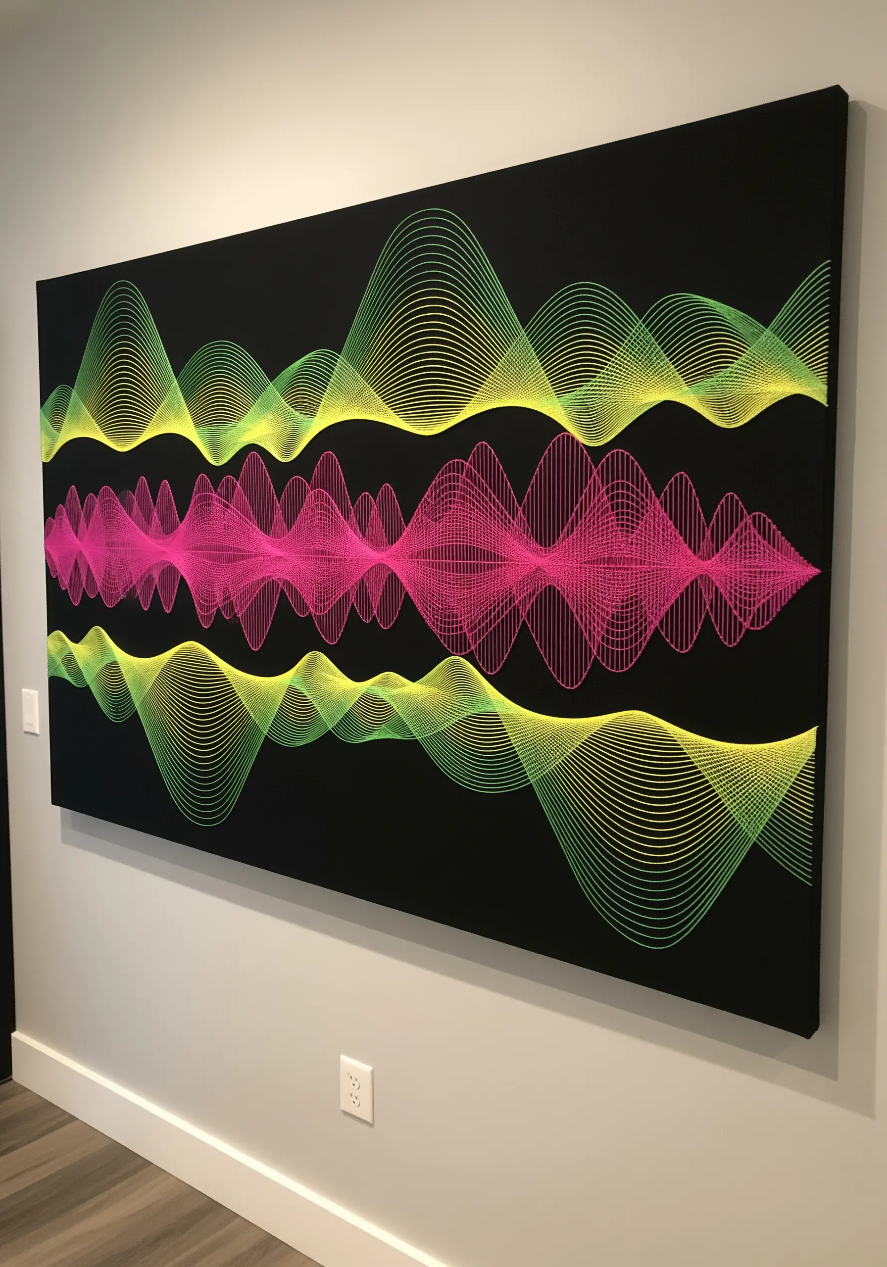 Large-scale embroidery of neon pink and green soundwaves on a black canvas.