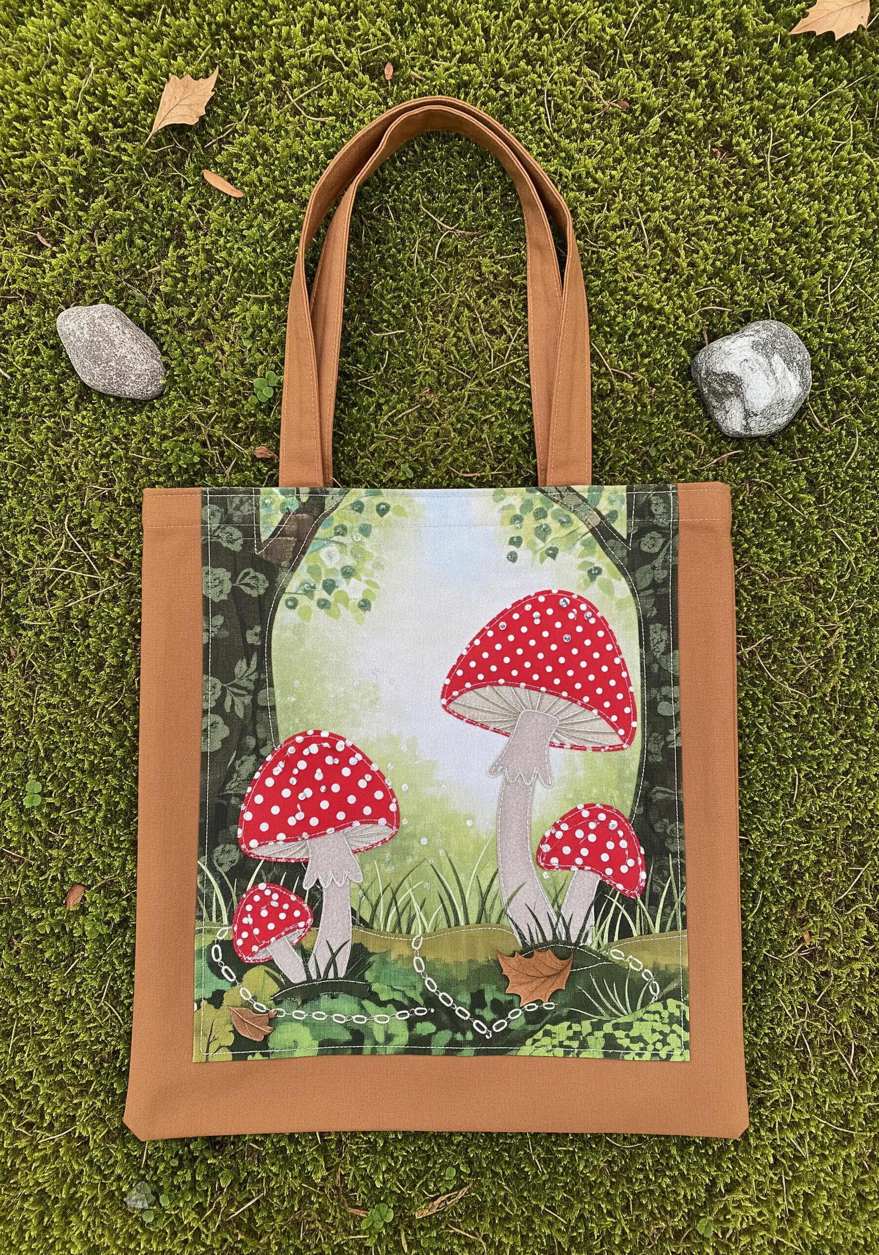 Appliqué tote bag featuring red and white toadstool mushrooms in a forest scene.