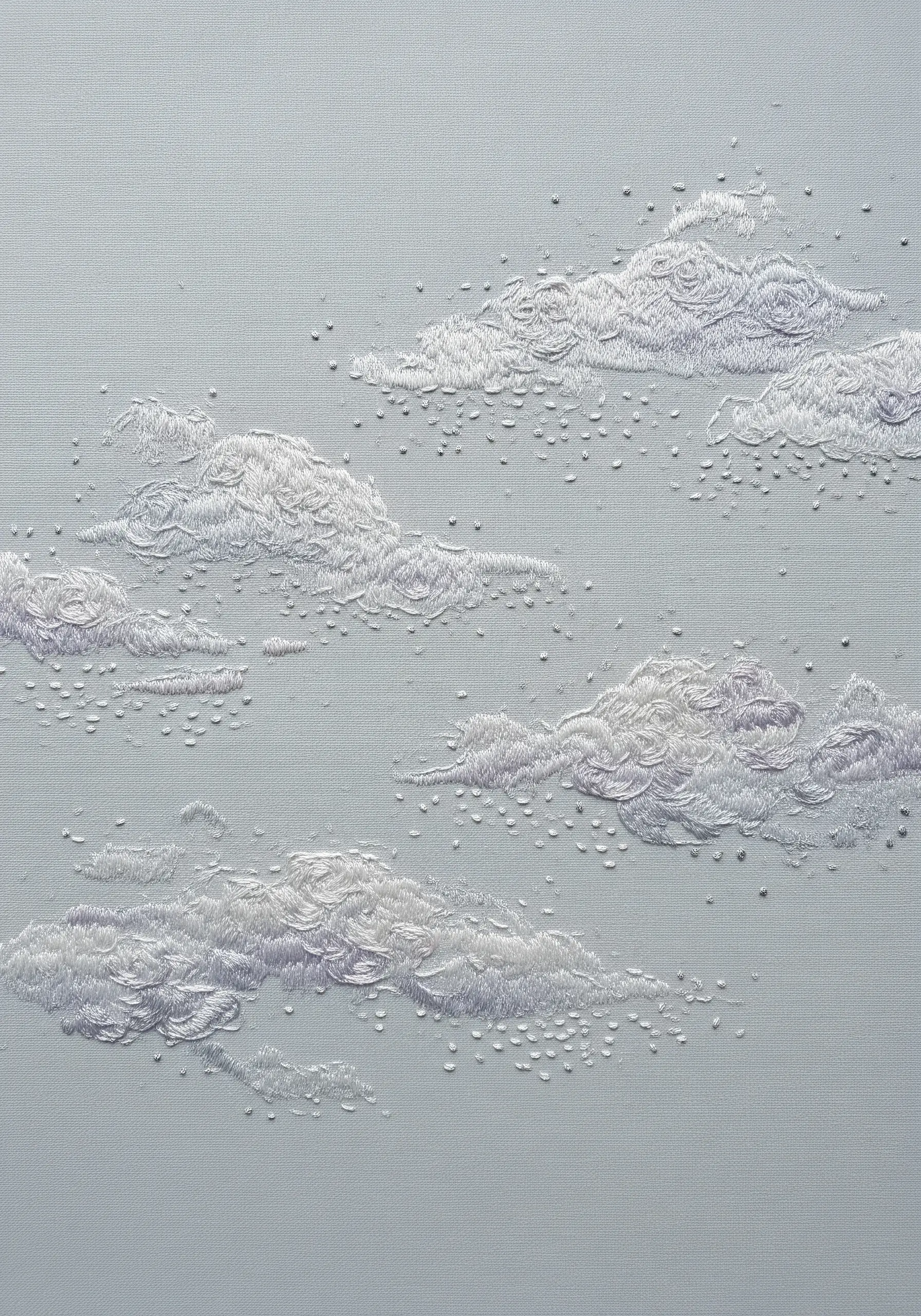 Subtle white and lavender clouds embroidered on light blue fabric with textured stitches.