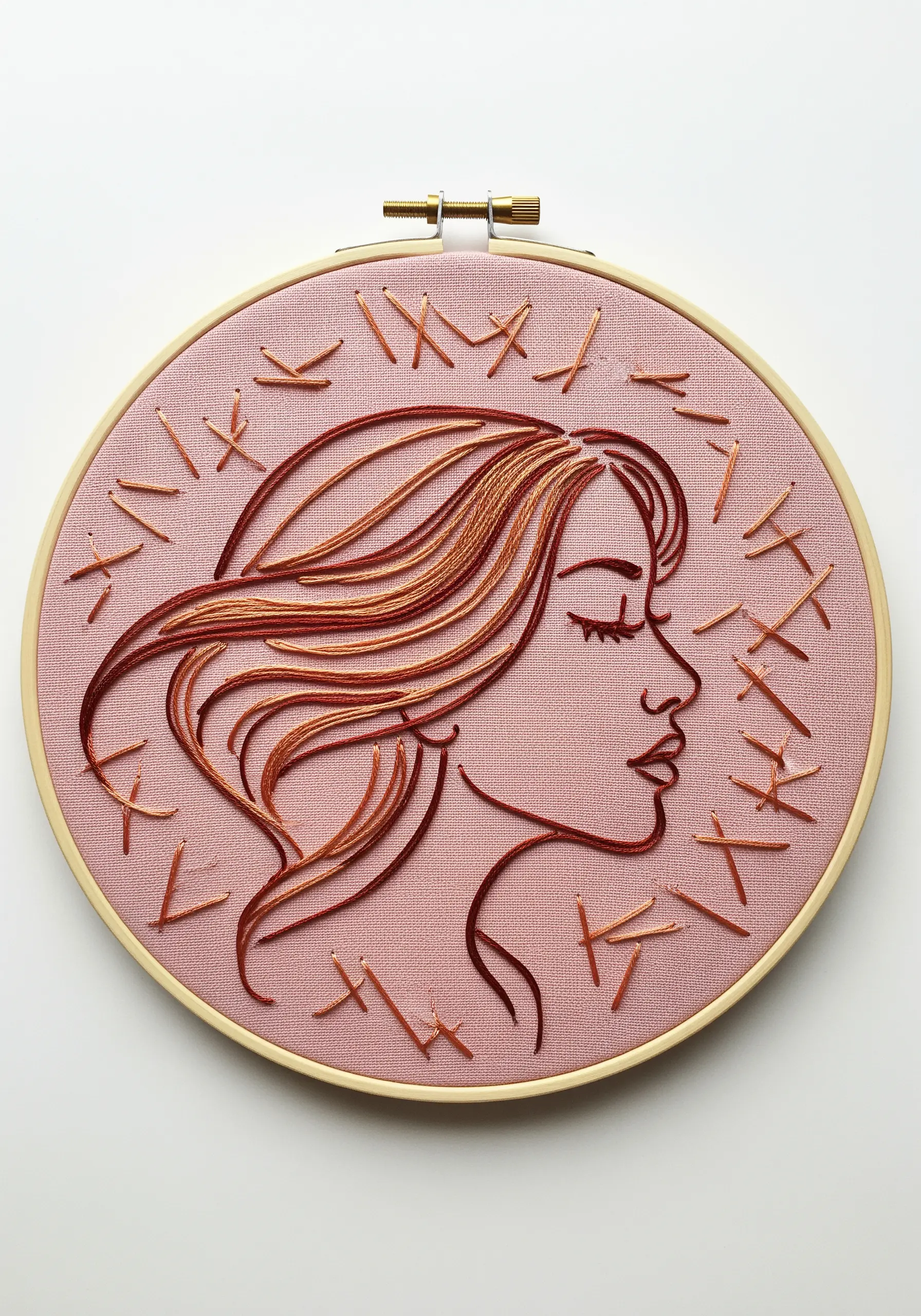 A line art portrait in negative space, with hair and abstract dashes stitched in reddish-brown thread.