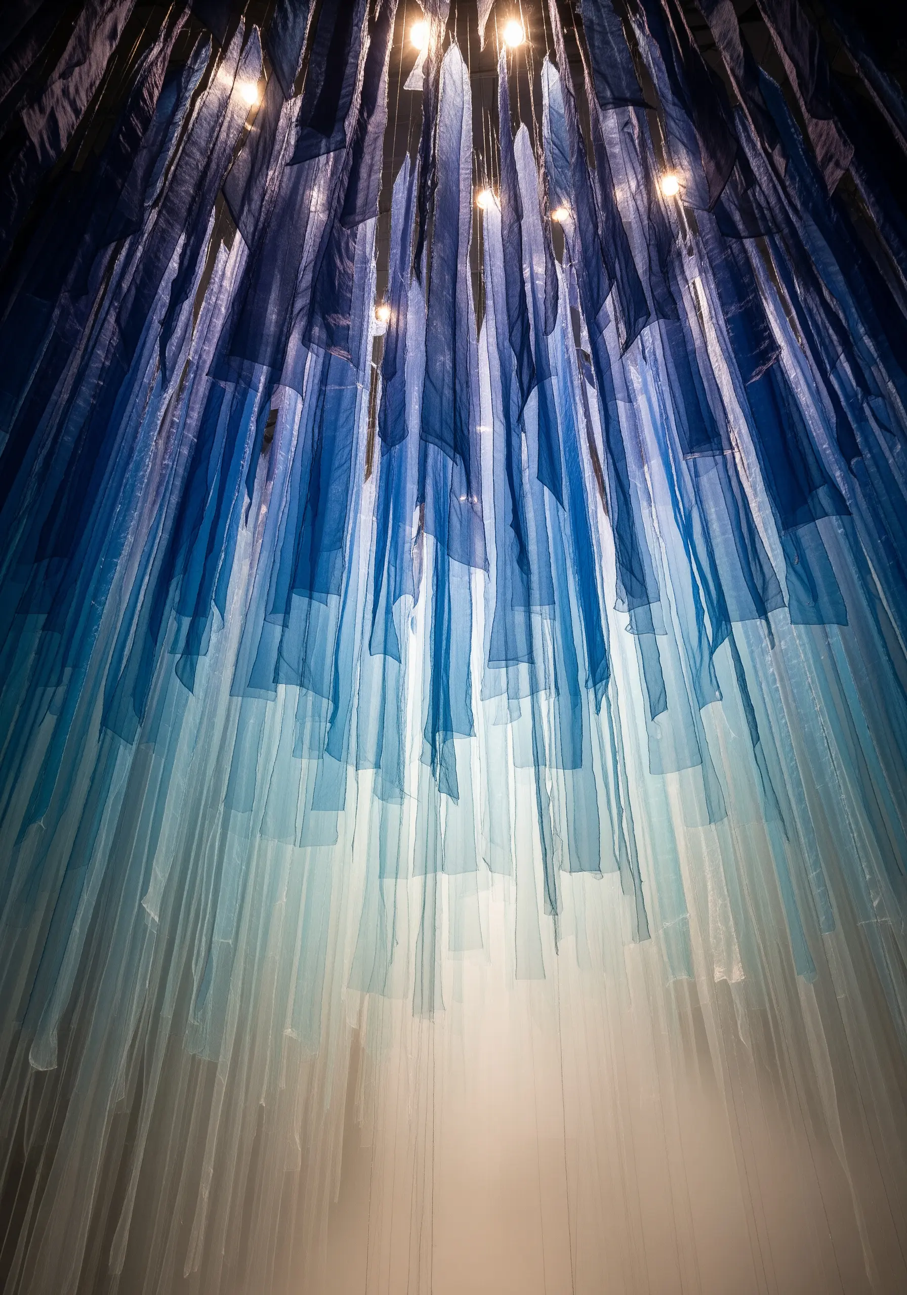 Ceiling installation of hanging blue sheer fabric strips