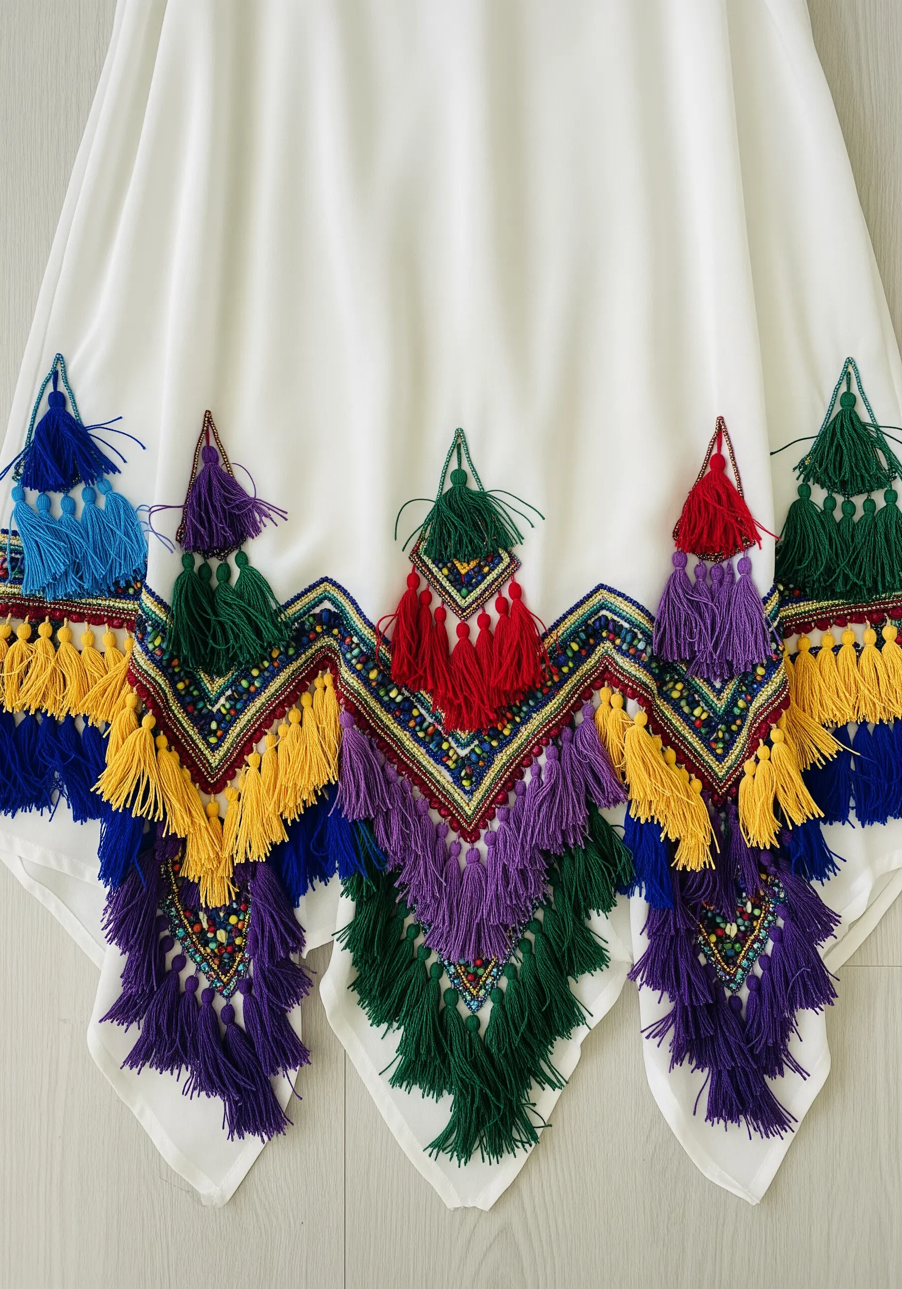 White dress with colorful embroidered geometric shapes and tassels