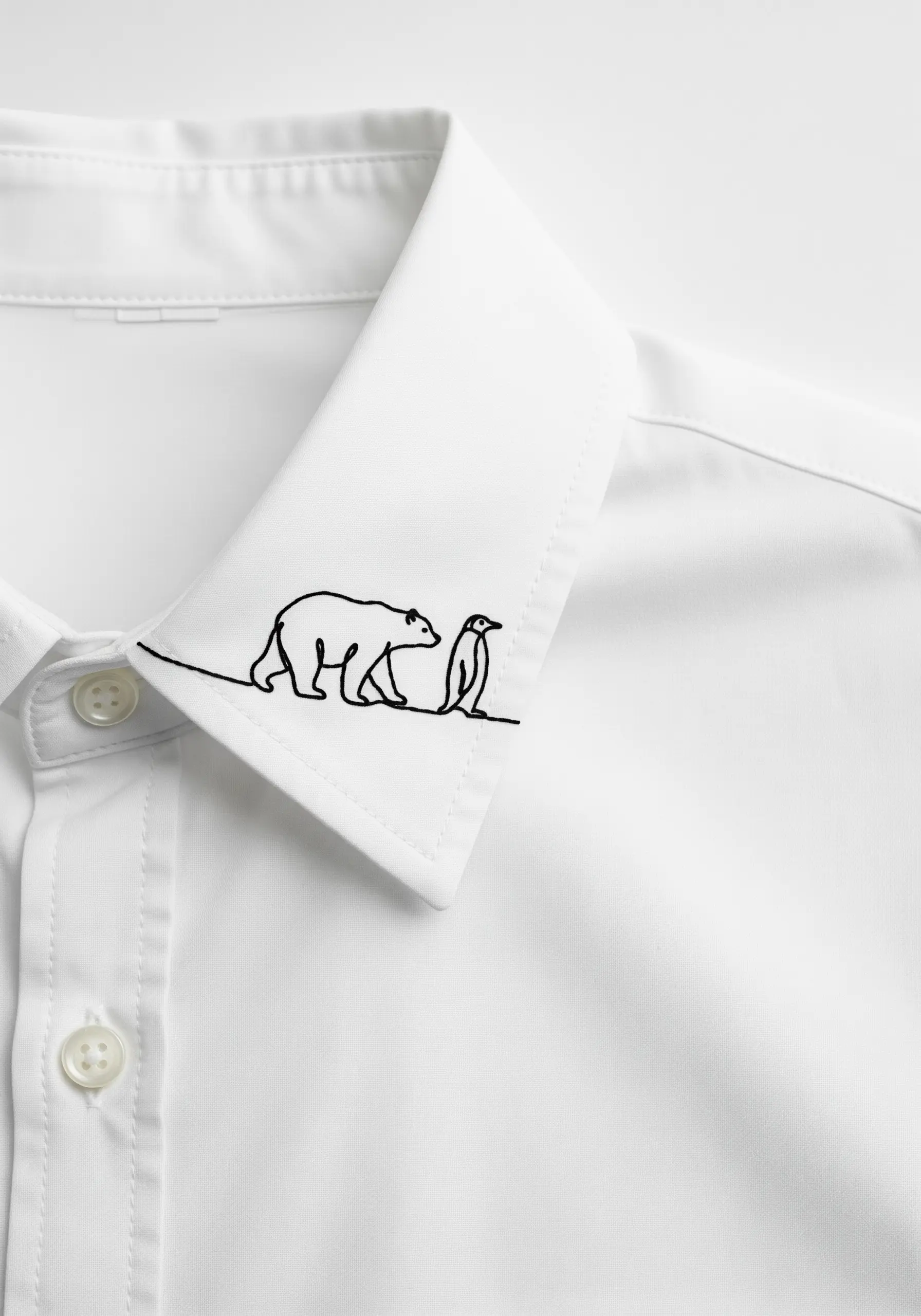 A single continuous black line embroidered on a white shirt collar forms a polar bear and a penguin.