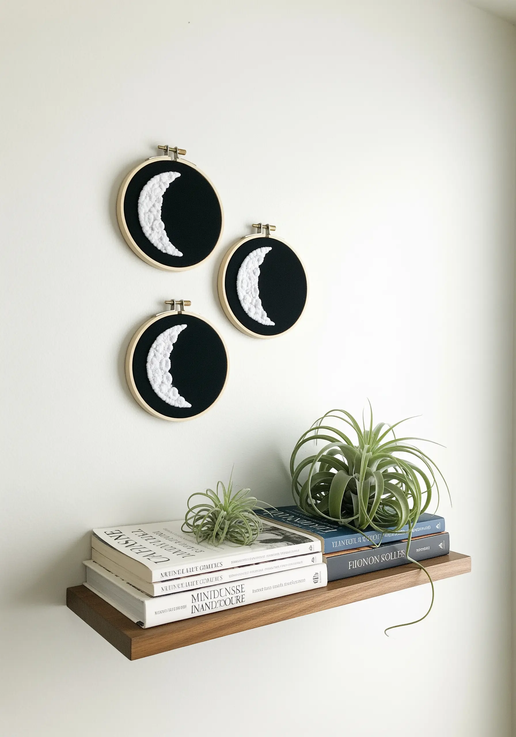 Three embroidered moon phases filled with white French knots on black fabric.