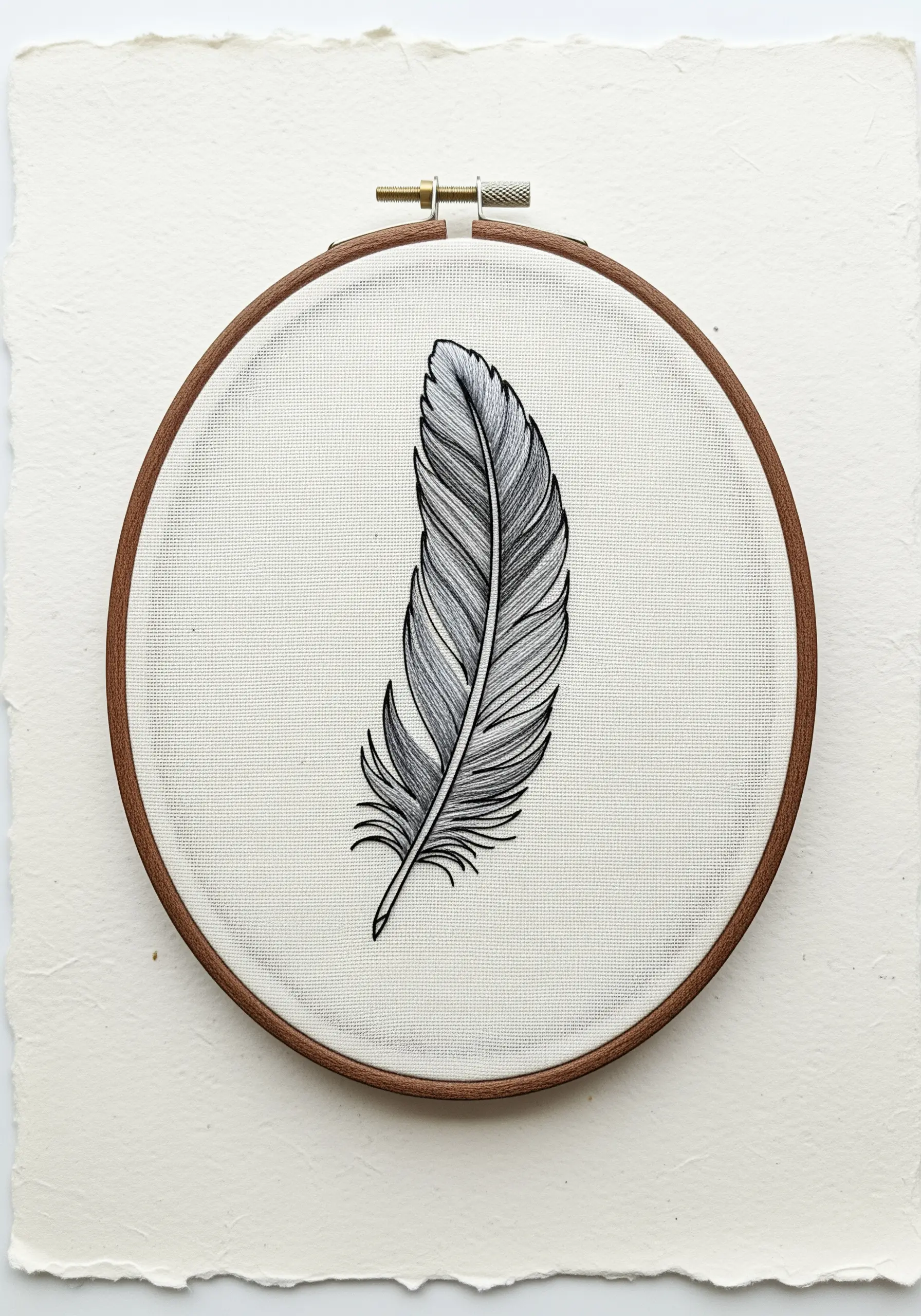 A highly detailed feather embroidered in shades of grey, black, and white thread.