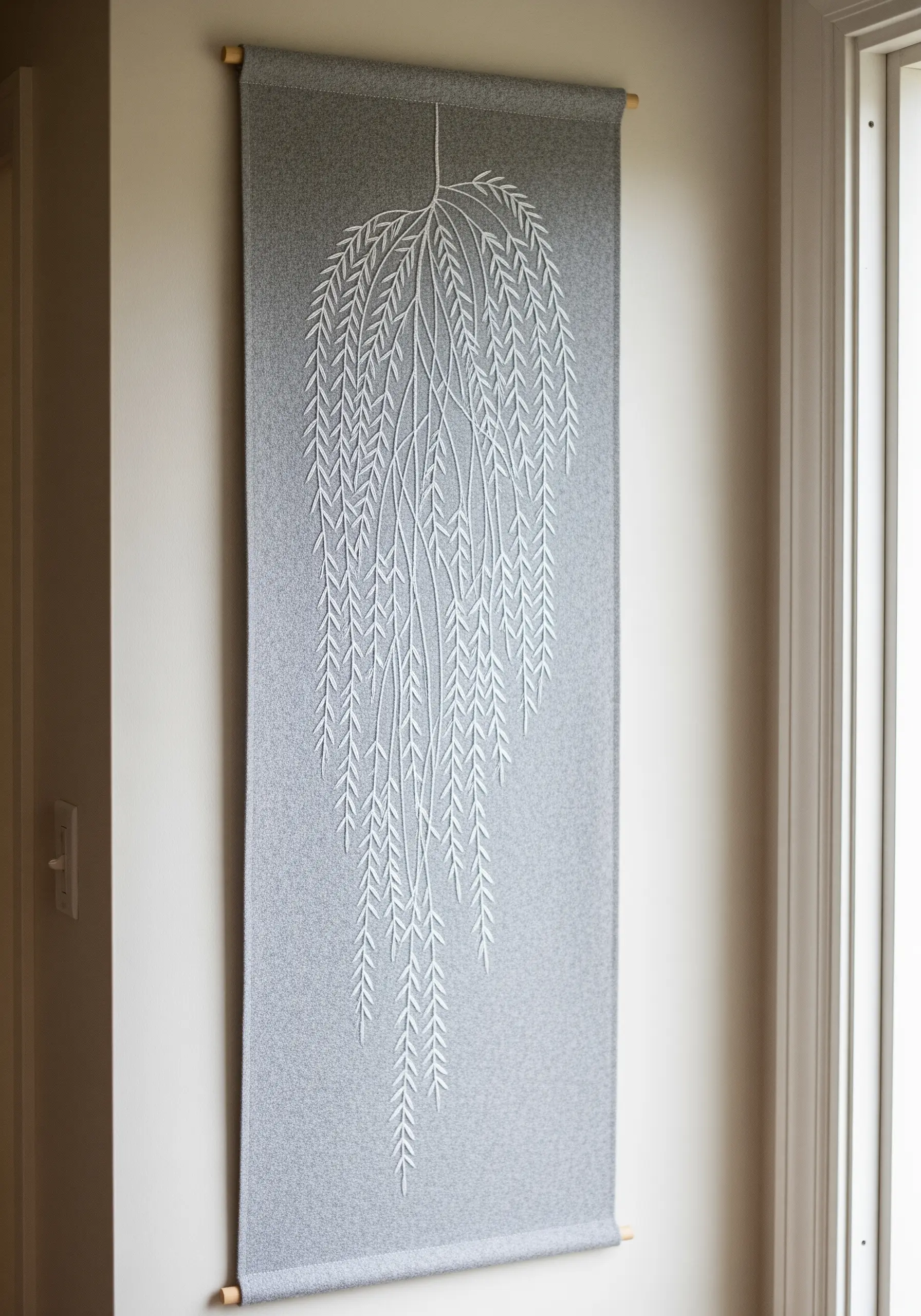 A tall, narrow grey wall hanging featuring a white embroidered weeping willow design.