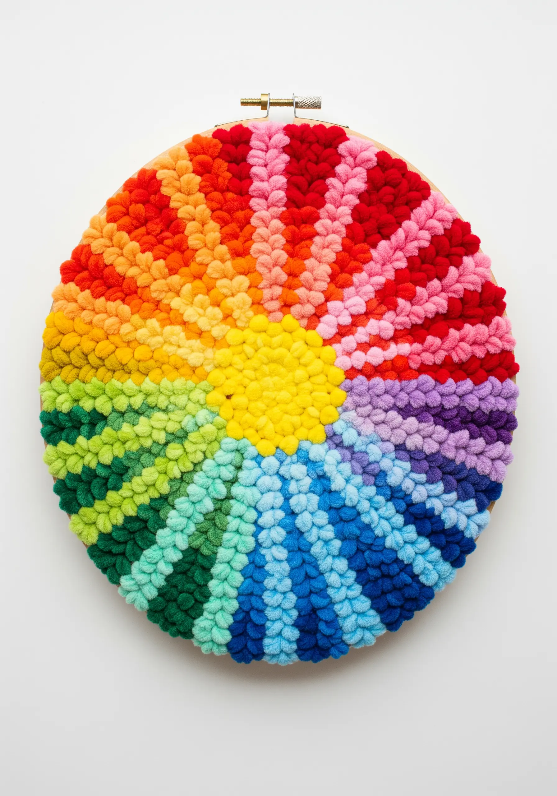 A vibrant rainbow color wheel in a hoop, stitched with highly textured, plush stitches.