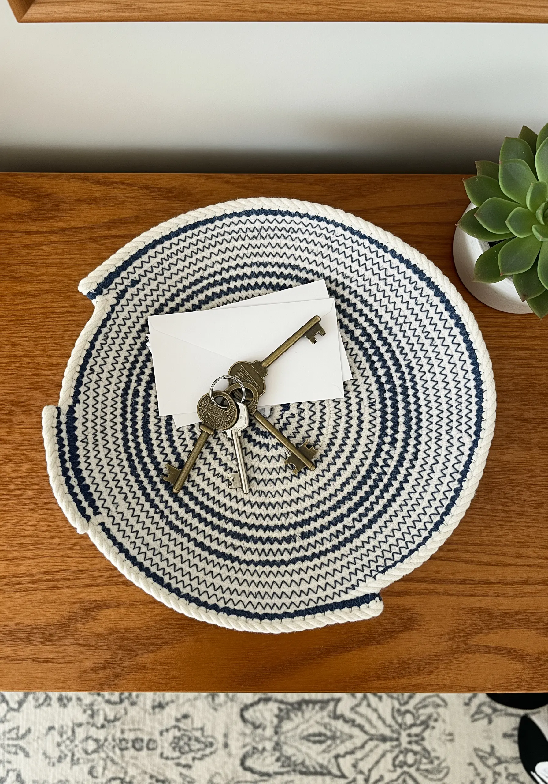 A coiled rope bowl with a navy and white spiral pattern, used as a catchall tray.