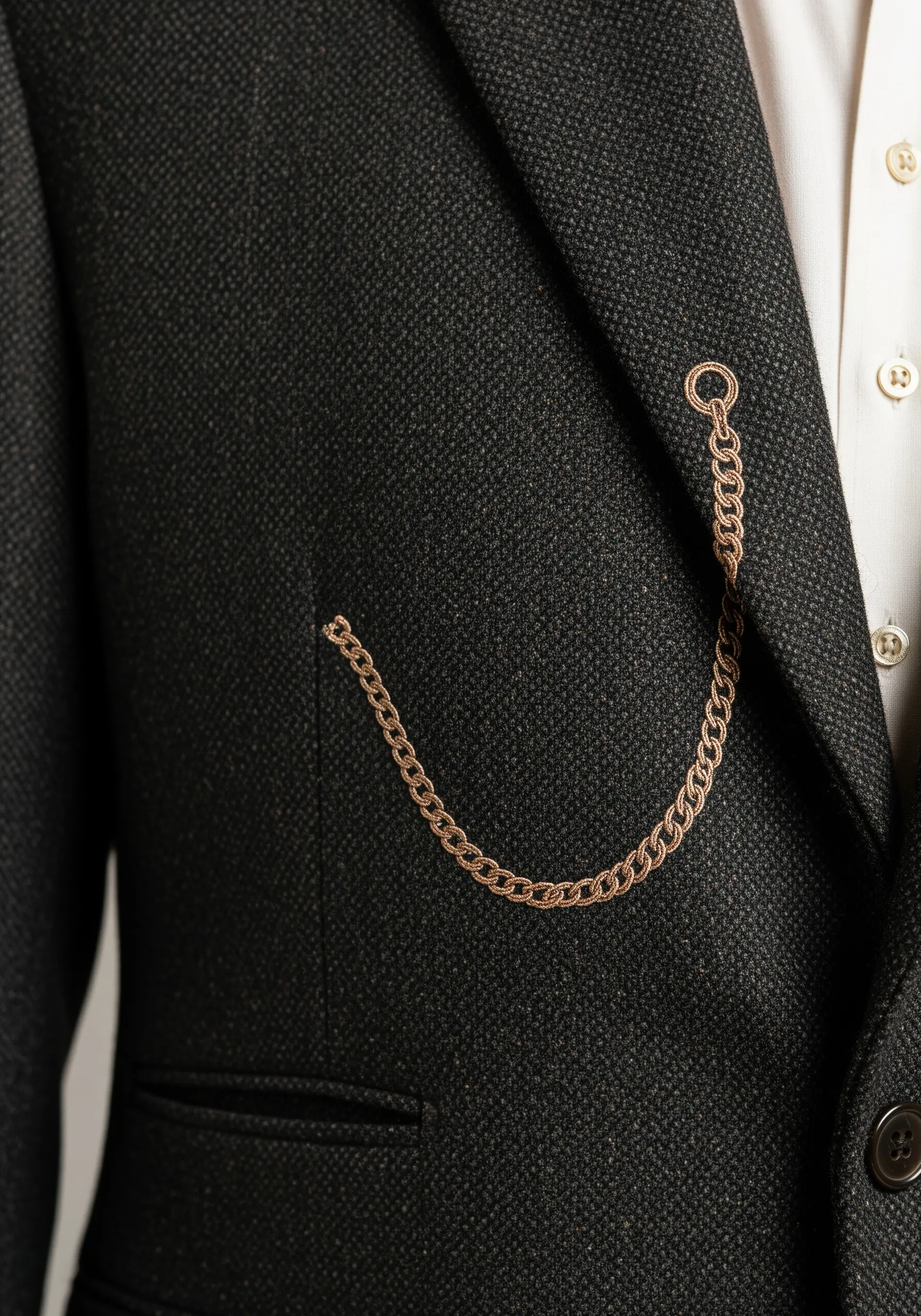 An embroidered metallic chain creating the illusion of a pocket watch.