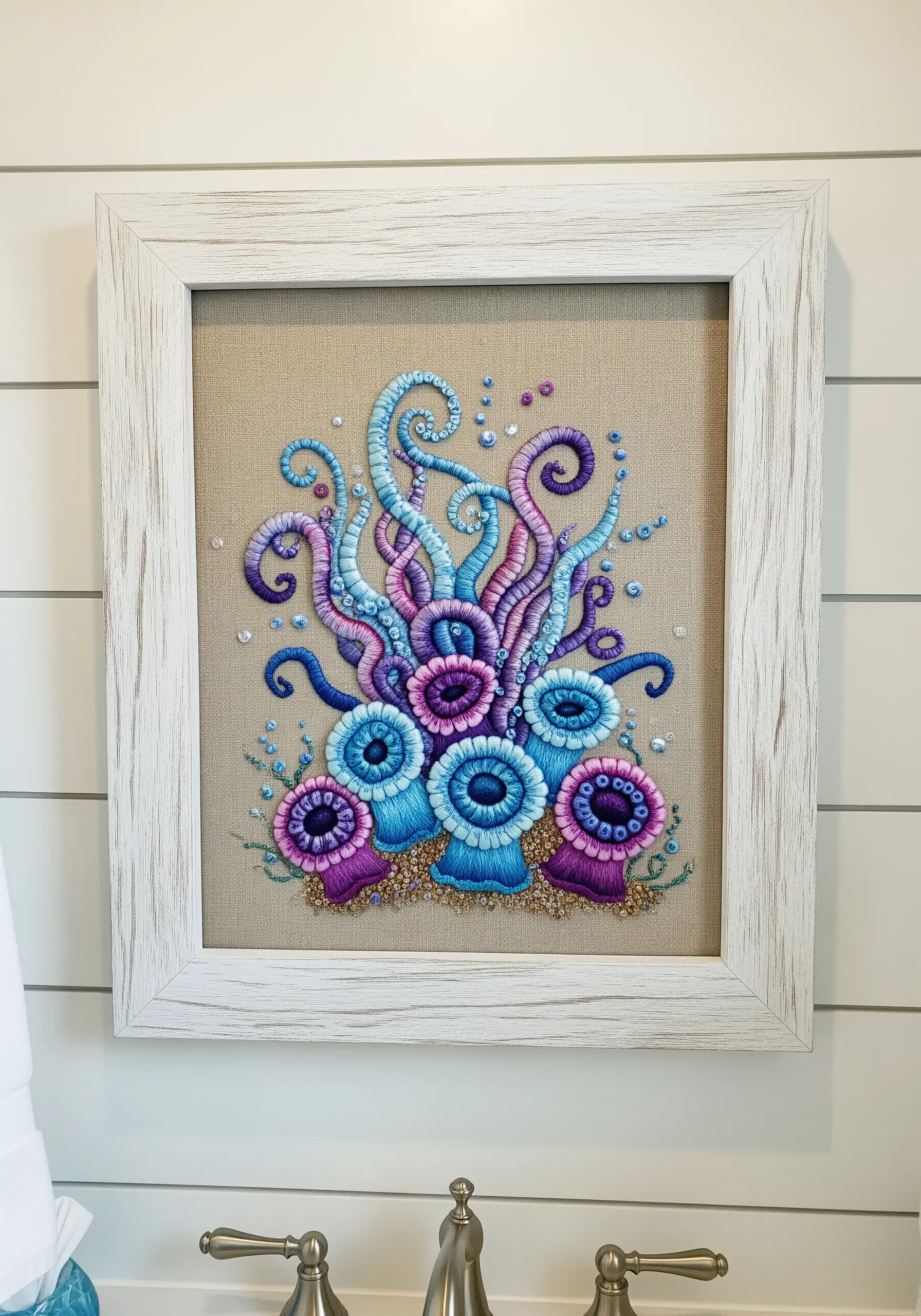 Framed embroidery of sea anemones and tentacles made with colorful, coiled bullion knots.