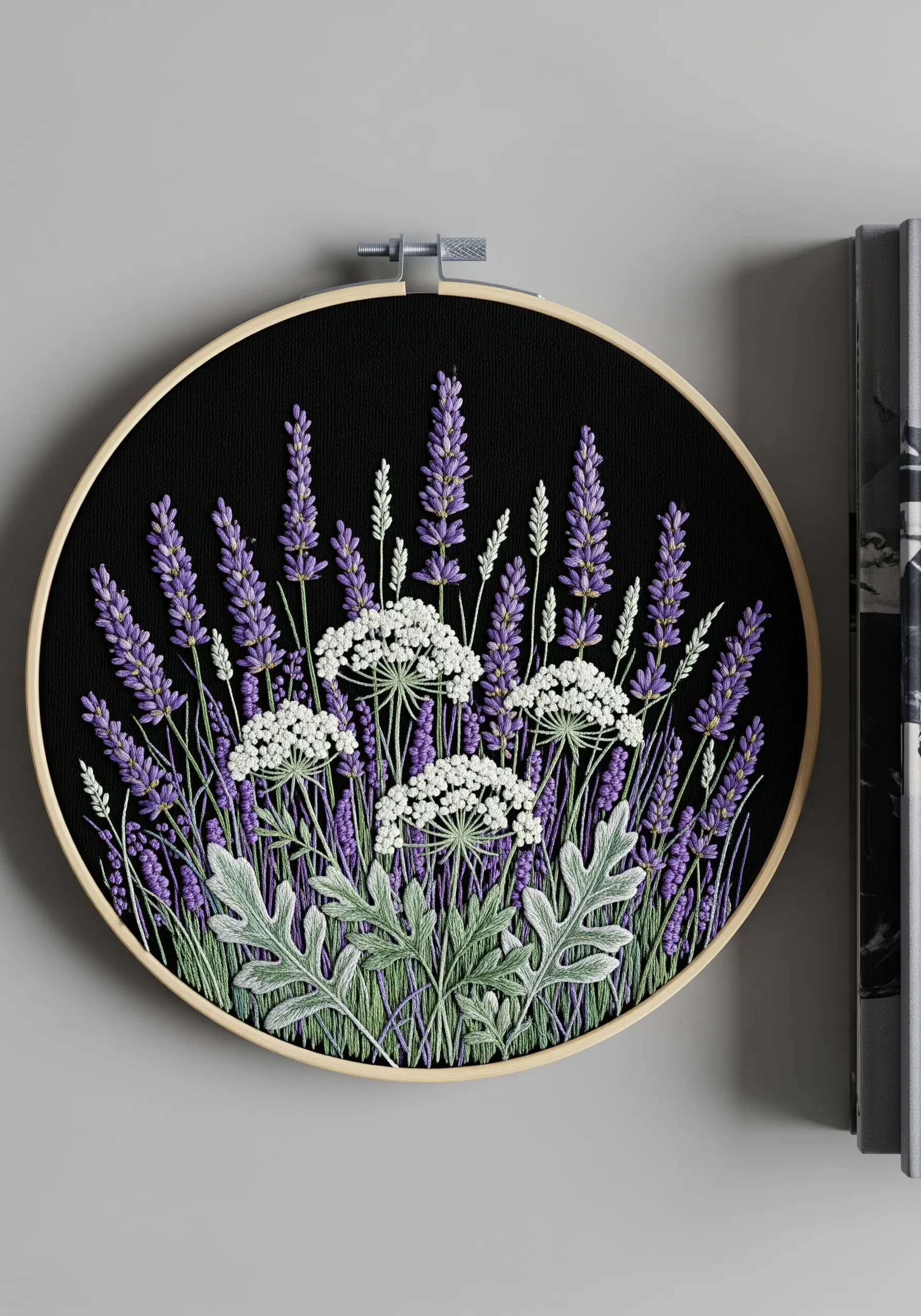 Lavender and Queen Anne's Lace embroidered on black fabric in a wooden hoop.