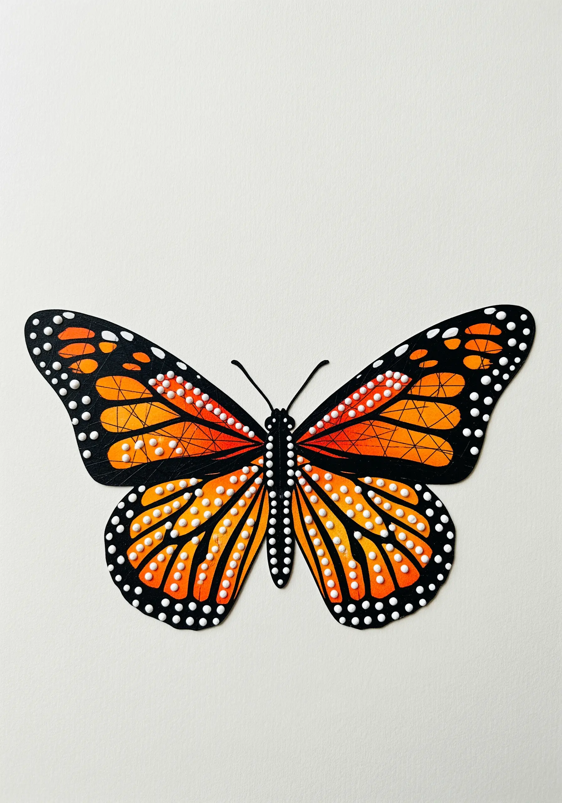 A monarch butterfly collage with vibrant orange and black paper, detailed with white dots.