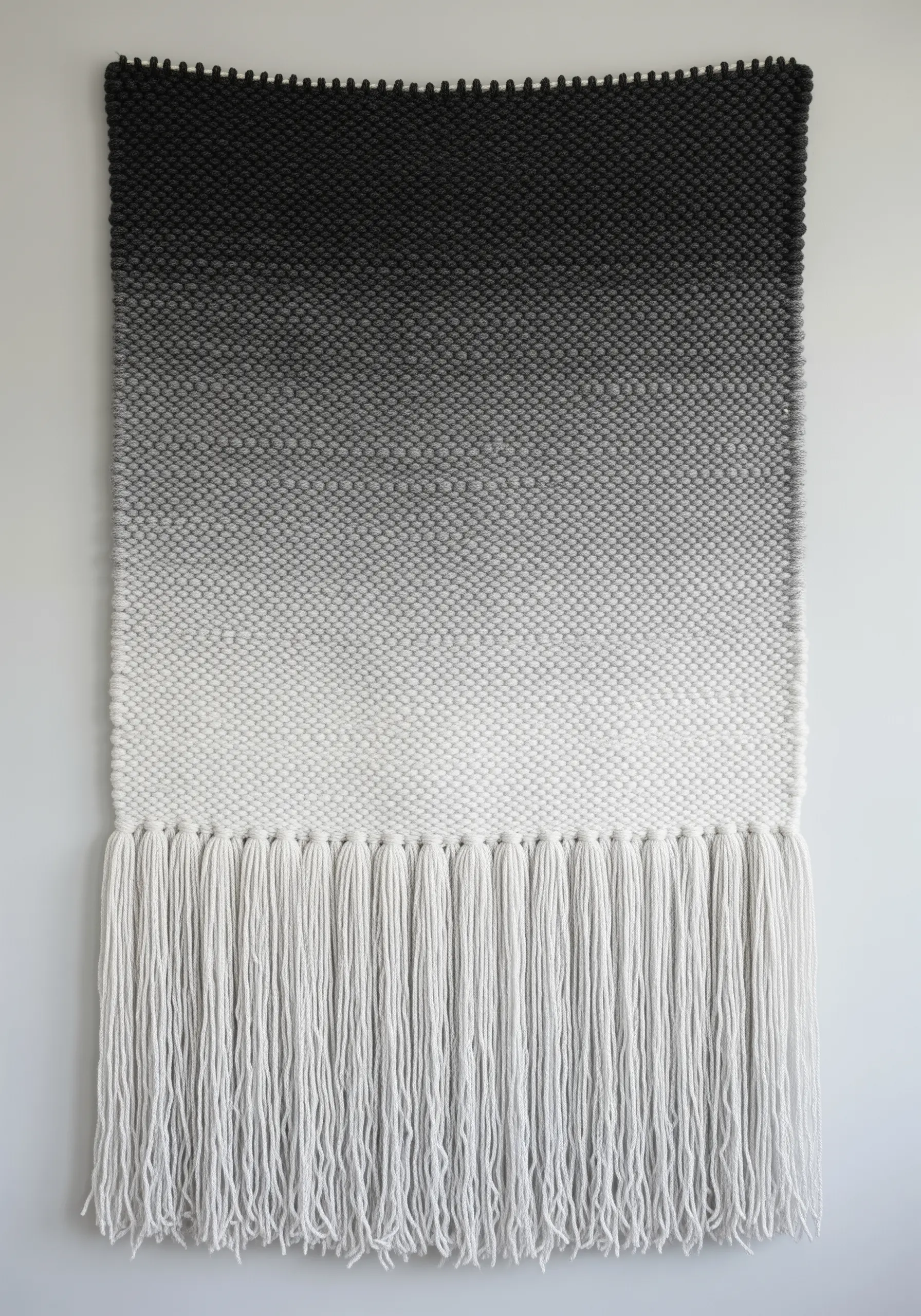A woven wall hanging with a smooth gradient from black to gray to white.