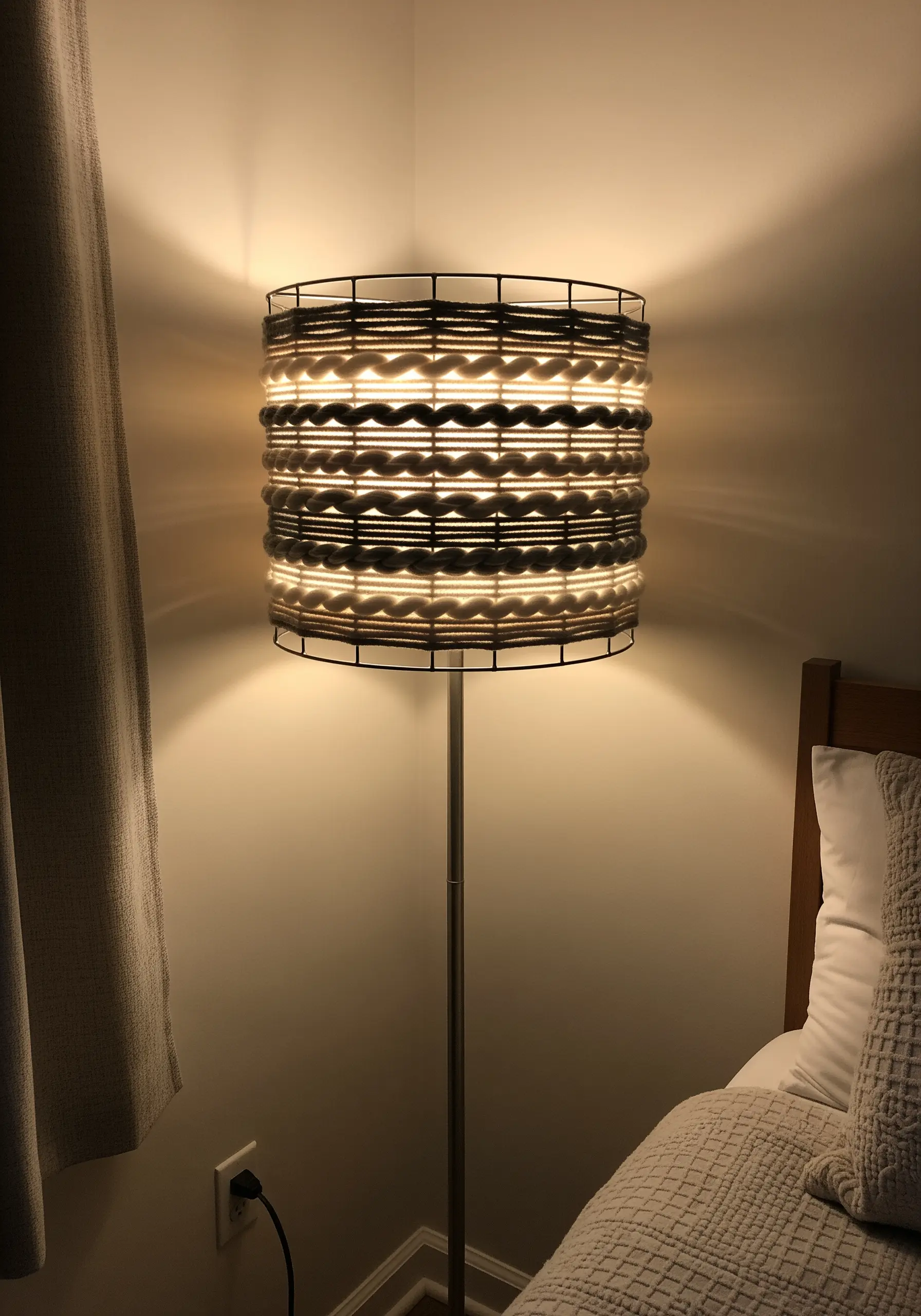 A lampshade made by weaving thick and thin yarns horizontally around a wire frame