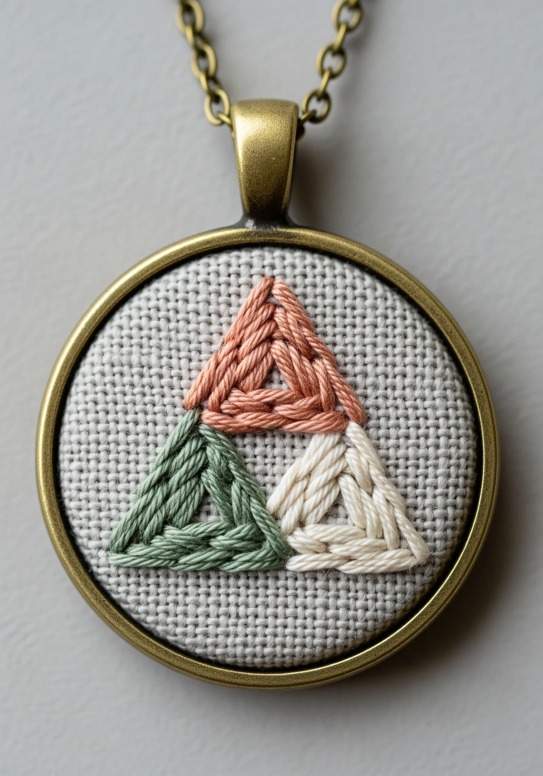 Three interlaced triangles in pink, green, and white creating a Celtic knot effect.
