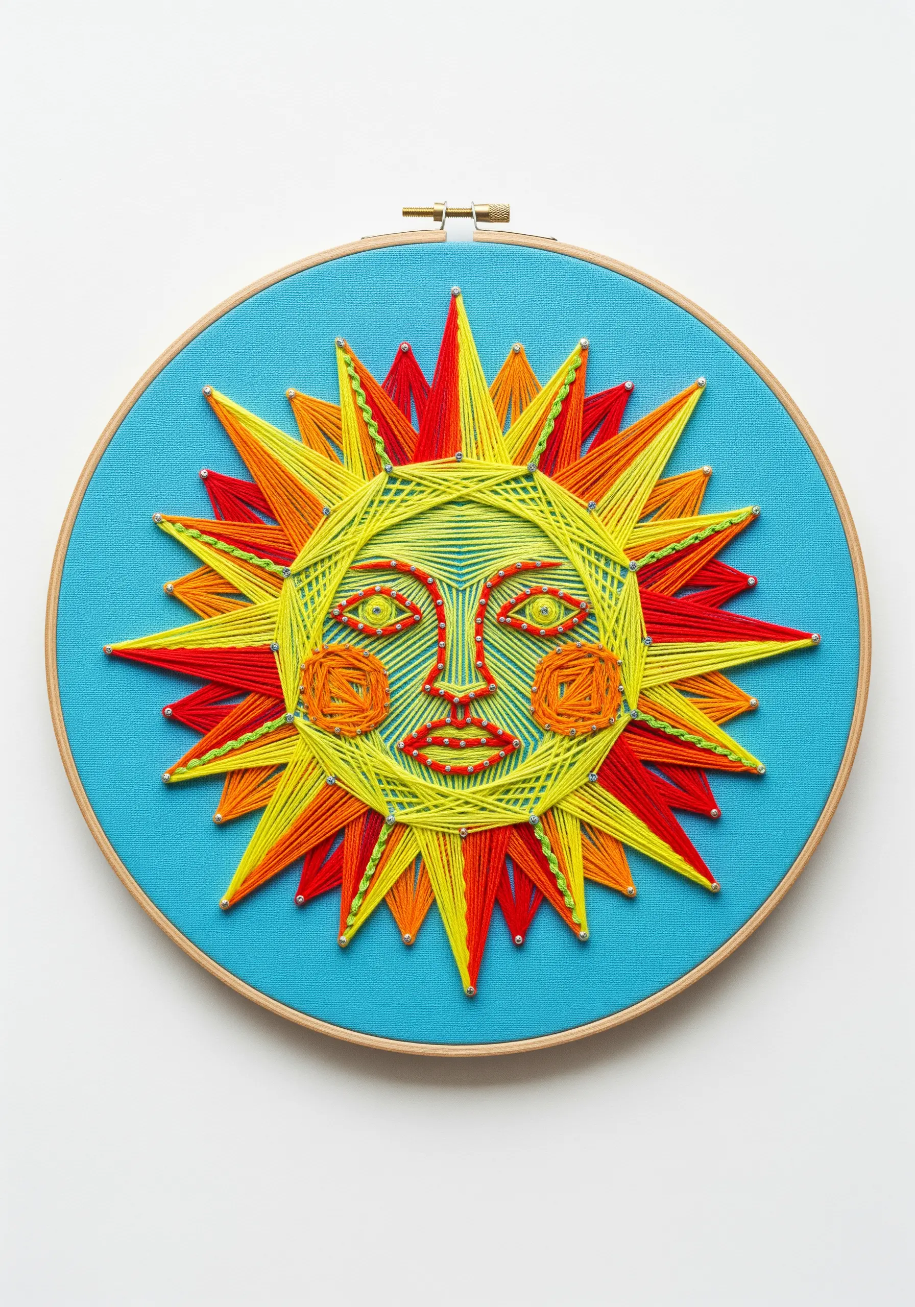 A stylized string art sun with a face, embroidered in yellow, orange, and red.