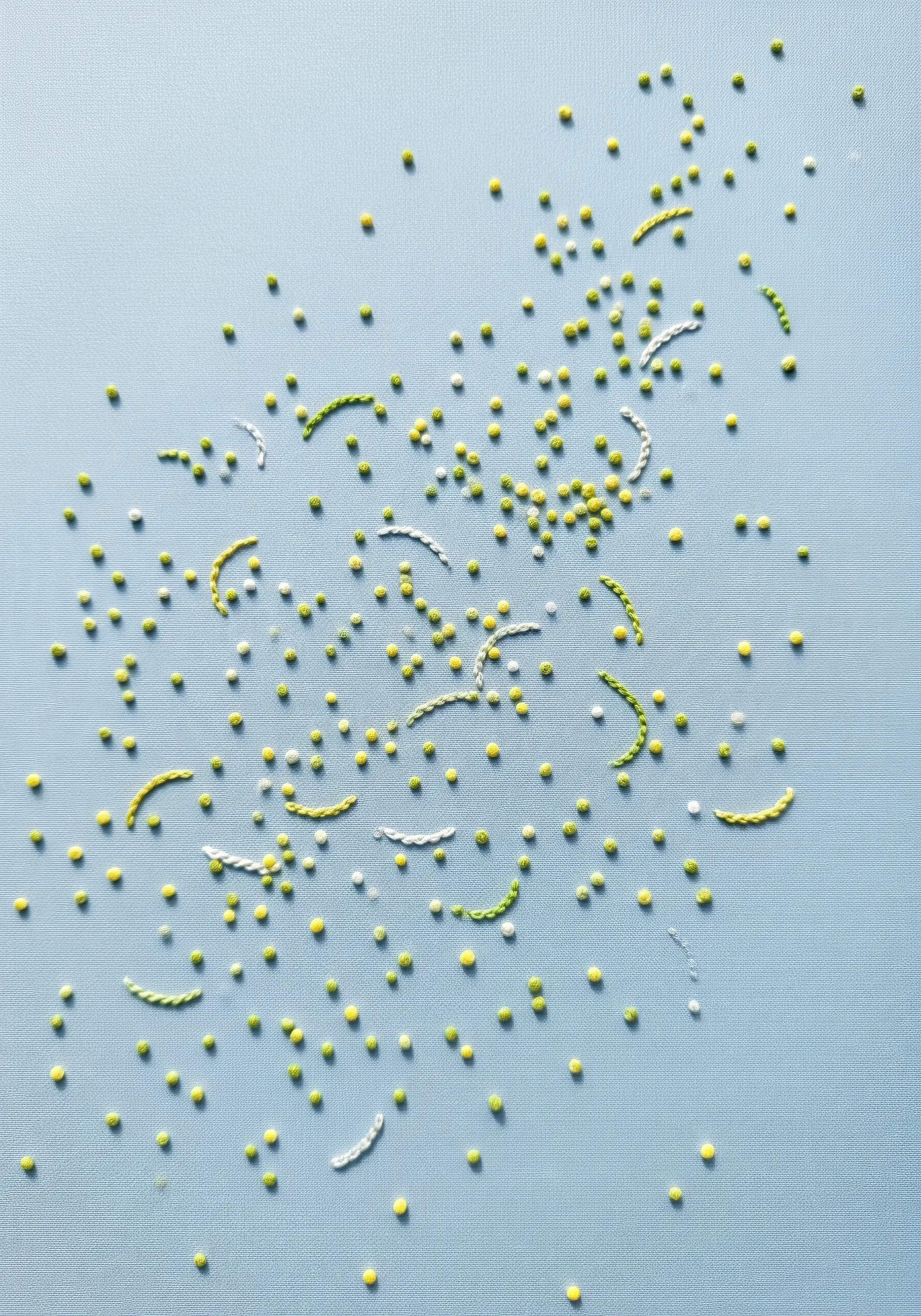 A sparse scattering of tiny yellow French knots and small white running stitches on a light blue background.