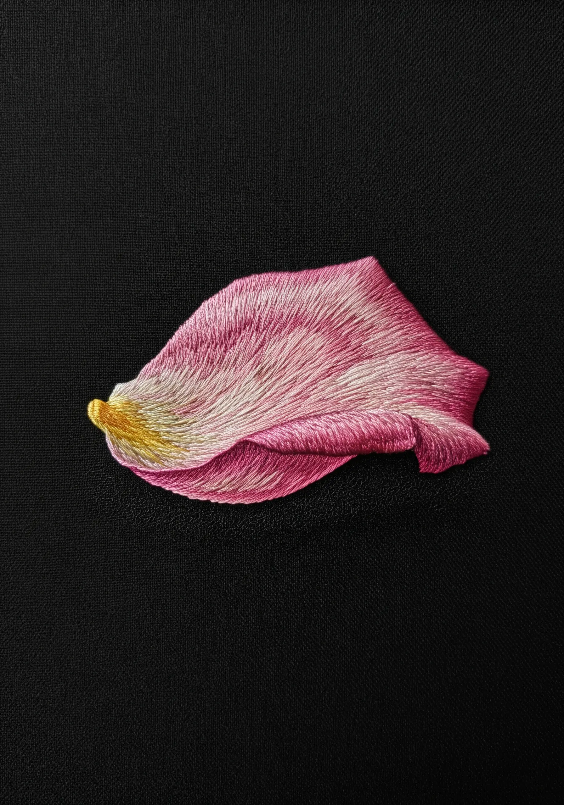 A single, hyper-realistic pink and white rose petal, thread-painted on a black background.